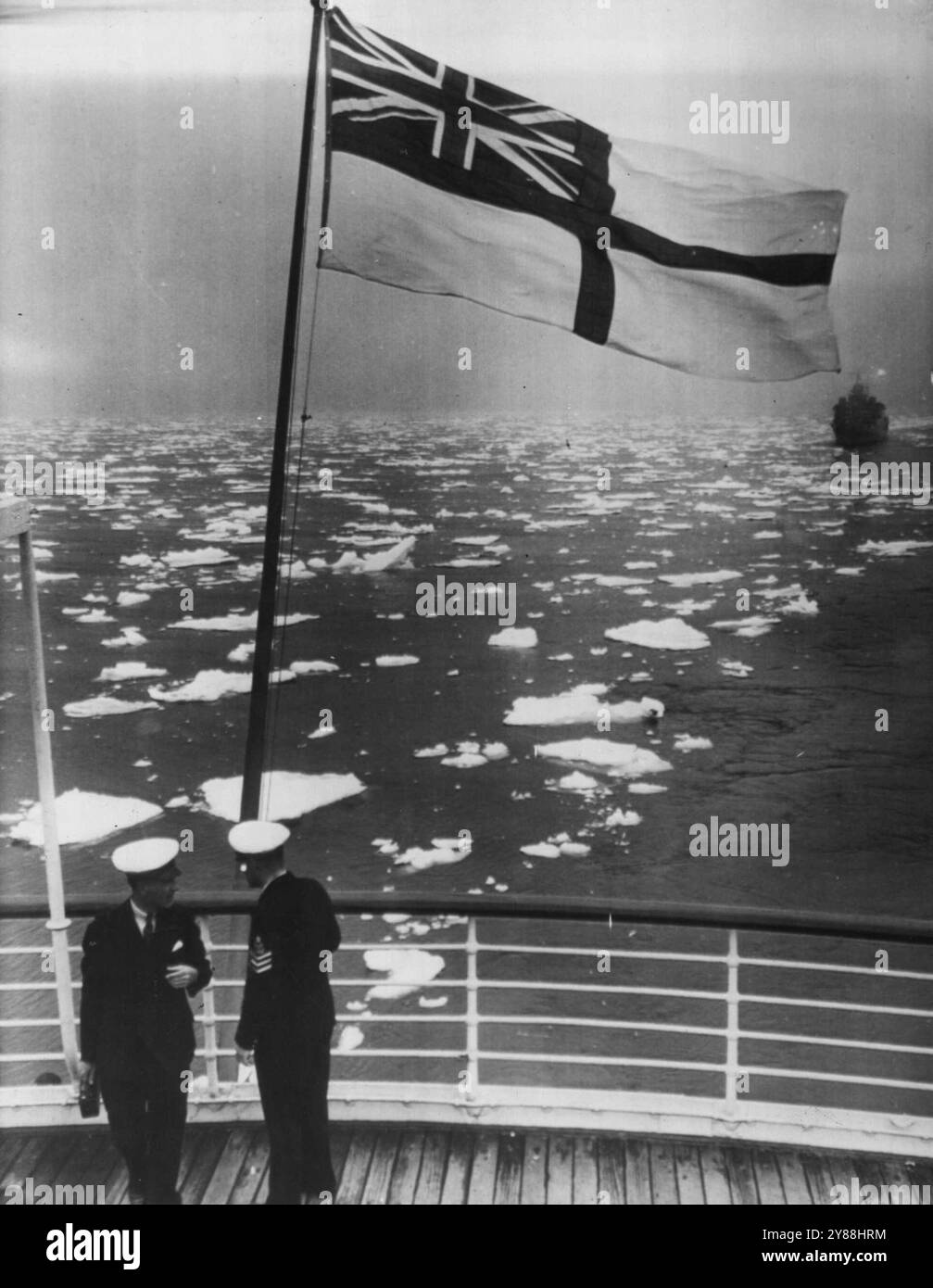 Royal Road Through Icy Seas – British Fähnrich fliegt in der Breeze, als das Schiff des Königs, die Empress of Australia, einen offenen Pfad im Eisfeld vor der kanadischen Küste verlässt, was die Ankunft der Royal Party für mehrere Tage verzögerte. Das Konvoyschiff kann im Hintergrund gesehen werden. Das Schiff war am Morgen des 17. Mai in Quebec geplant. Mai 1939. (Foto von zugehörigem Pressefoto). Stockfoto