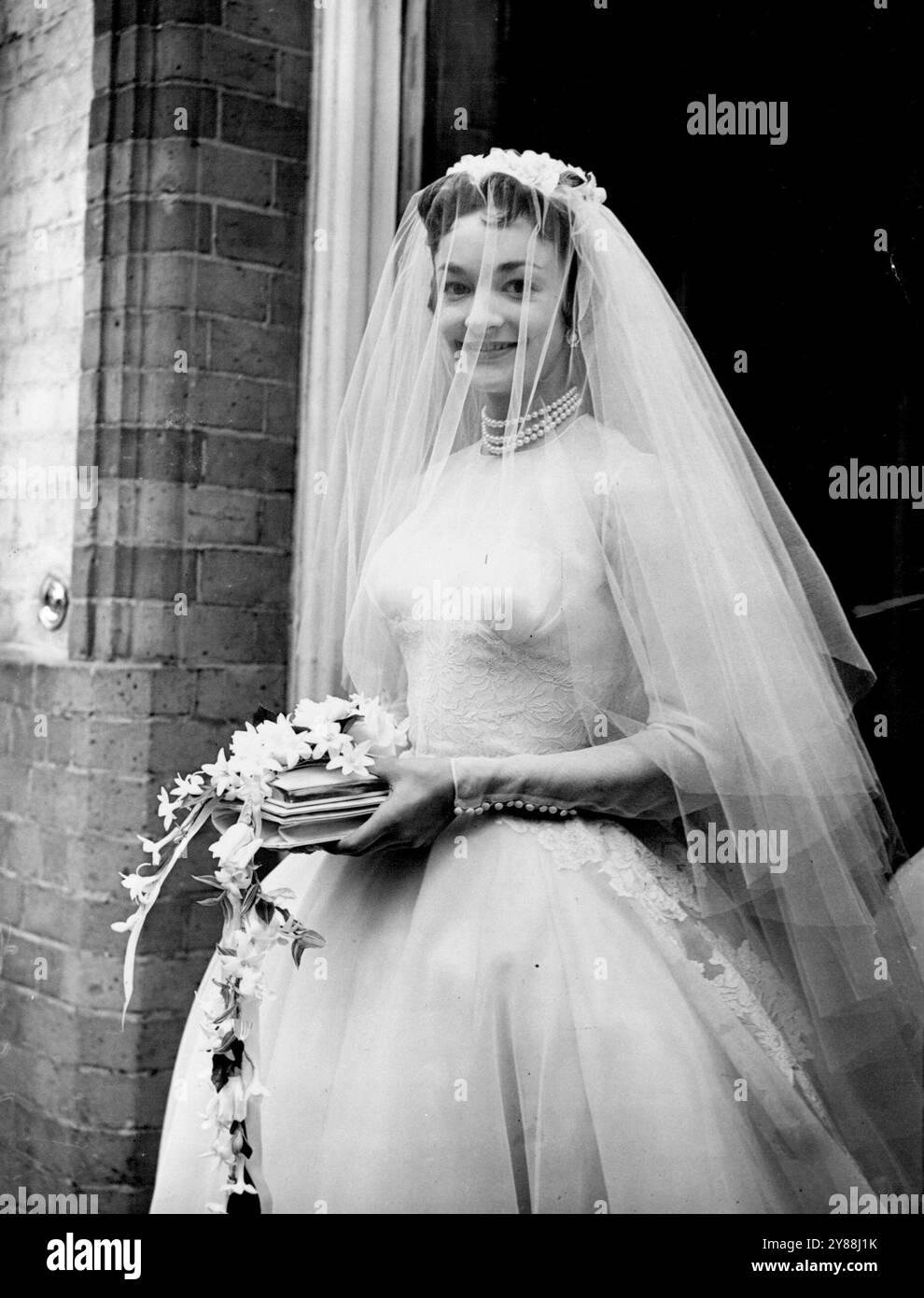 Eine Posy for the BrideBride mit einem Posy auf ihrem Gebetsbuch ist Lady Mary Baillie-Hamilton, eine enge Freundin von Prinzessin Margaret und eine der Ehrenmädchen der Königin bei der Krönung. Die Tochter des Earl und der Countess of Haddington war heute die Braut von Mr. Adrian Bailey in St. James's, Spanish-Place. Juli 1954. Stockfoto