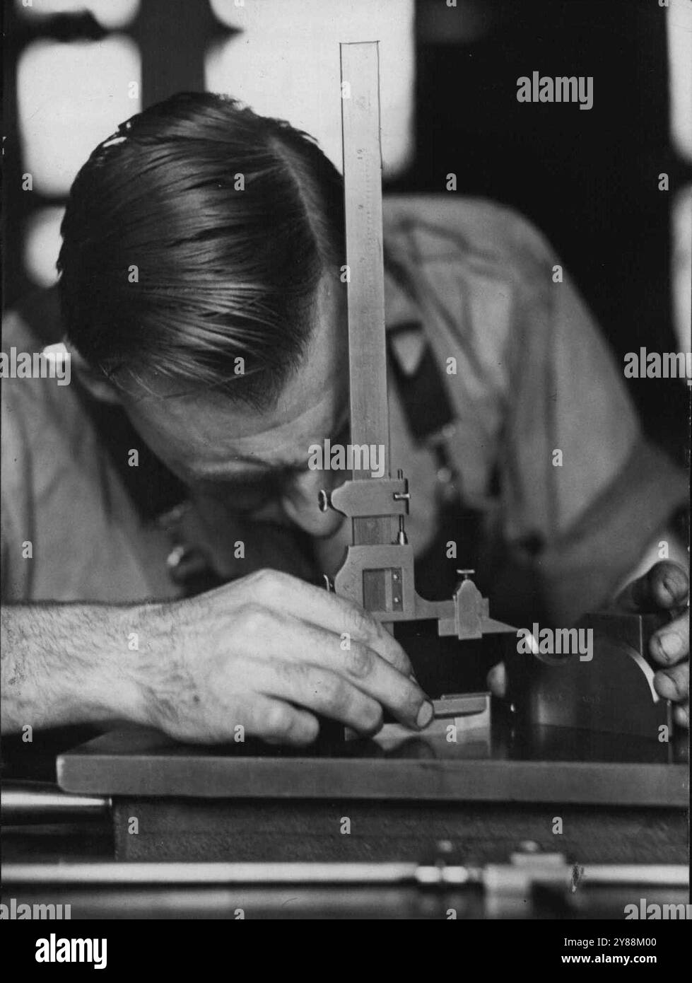 Die exakte Messung wird durch den Einsatz von empfindlichen Instrumenten wie diesem gewährleistet. Ein junger Mann, der Werkzeuge an der Technischen Hochschule Ultimo lernt. April 1940. Stockfoto