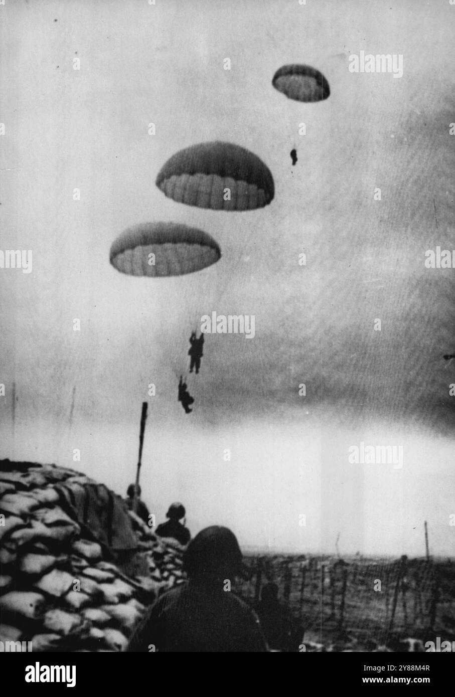 Fallschirmjäger fallen in Dien Bien Phu -- dieses Foto, eines einer Serie, die gerade in Saigon empfangen wurde, zeigt einen Vorfall in der Schlacht, die jetzt um Dien Bien Phu in Nordvietnam wütet, wo die französischen Streitkräfte nun gegen die Belagerungskräfte in der bittersten Aktion des achtjährigen Krieges in Indochina kämpfen. Hier werden französische Verstärkungen gezeigt, die mit dem Fallschirm in den Perimeter für den Gegenangriff geschossen wurden. März 1954. (Foto von zugehörigem Pressefoto). Stockfoto