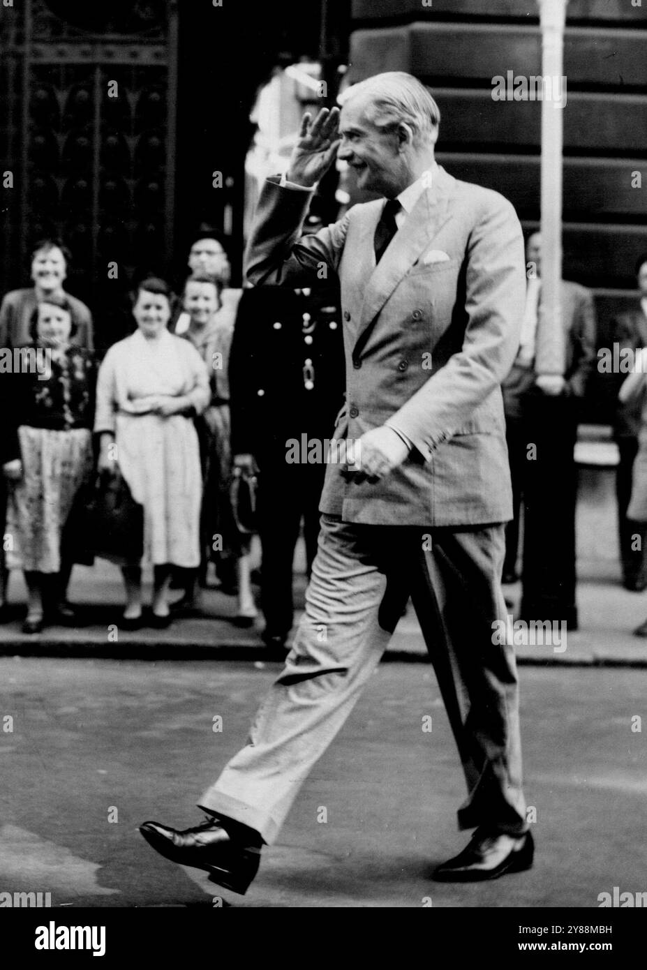 Erstes Treffen des neuen Kabinetts -- Außenminister Anthony Eden, winkt, als er an der Straße 10 ankommt, für die erste Kabinettssitzung seit der Umgruppierung. August 1954. (Foto von United Press Photo). Stockfoto