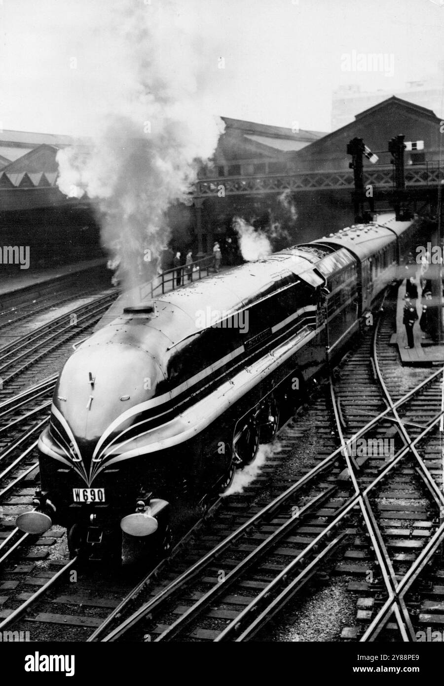 Deutsche Experten nehmen an der Fernprüfung VON Riesen New L.M.S. Teil ***** Lok -- der Zug mit der Lokomotive 'Duchess of Gloucester' verlässt Euston heute Morgen. 15 deutsche Eisenbahnexperten - hohe Beamte der Reichsbahn - sehen diese Woche die neuesten Entwicklungen im britischen Lokomotivbau. Sie verließen heute Morgen Euston Station nach Glasgow als Mitglieder einer Gruppe von 120 Lokomotivexperten, die an der Sommerversammlung der Institution of Locomotive Engineers teilnahmen. Der Zug wird von der riesigen New L.M.S. stromlinienförmigen Lokomotive gezogen ***** Und diese Reise ist ein Opportu Stockfoto