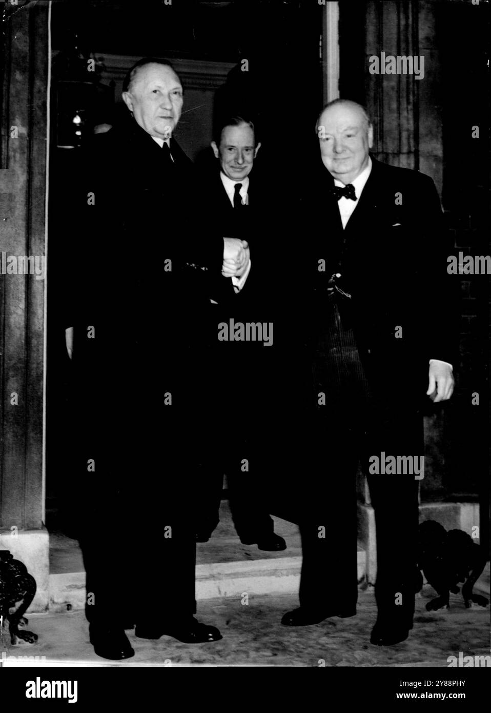 Churchill sieht Adenauer vor der Tür: Der Premierminister kommt nach Gesprächen mit dem Bundeskanzler Dr. Konrad Adenauer an die Tür der Straße 10 in London. Die britische und westdeutsche Führung schütteln sich beim Abschied die Hand. Februar 1952. (Foto von zugehörigem Pressefoto) Stockfoto