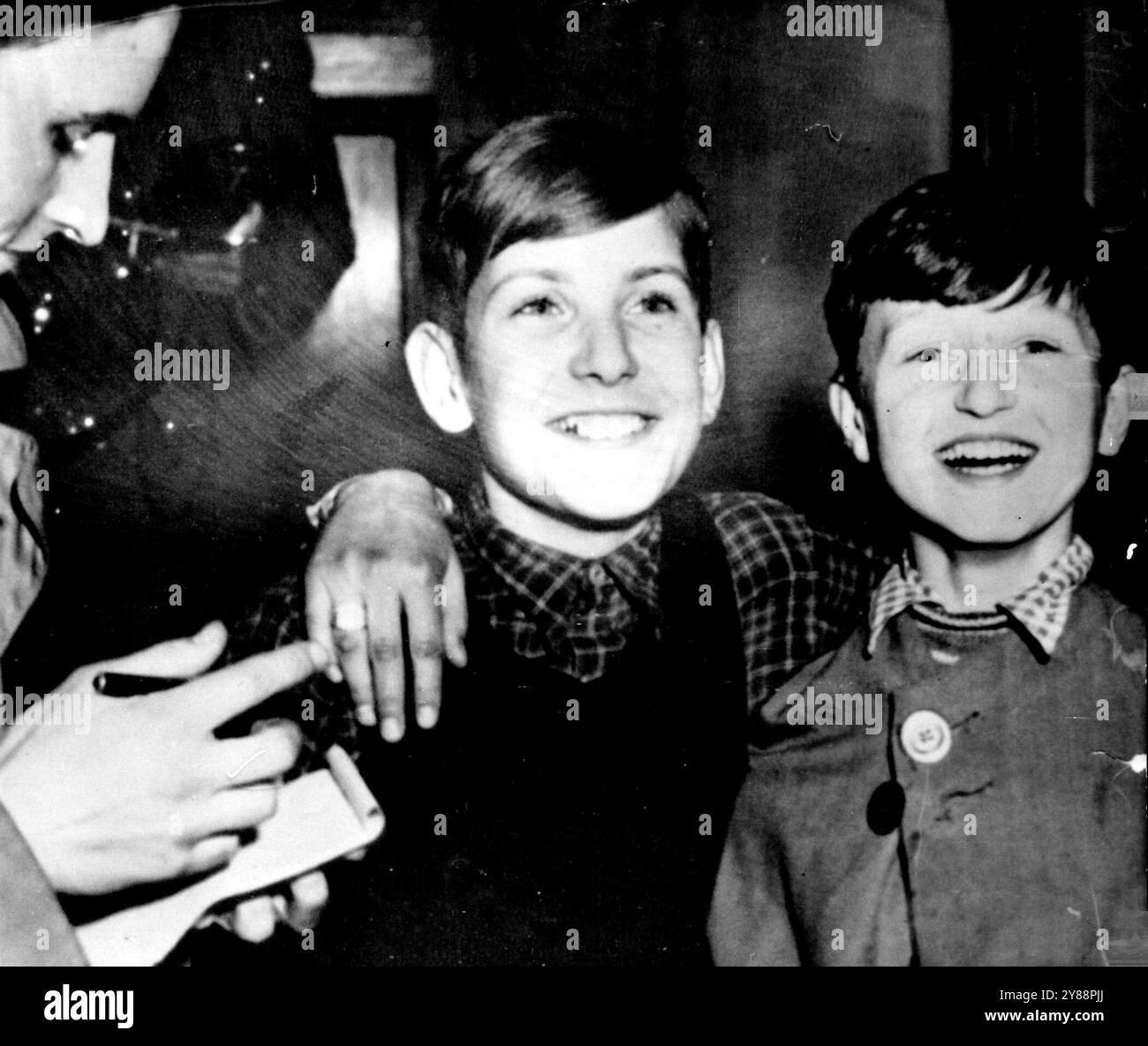 Junge, die an Post Adenauer Domb bezahlt wurden: Diese beiden Jungen erhielten fünf Schilling von je zwei Männern in einer Straße in München, Deutschland, um am 27. März ein Paket an den Bundeskanzler Konrad Adenauer zu schicken. Sie wurden misstrauisch und brachten das Paket in das Münchner Polizeipräsidium, wo es explodierte, einen Bombenentsorgungsexperten tötete und drei Polizisten verletzte. Die Jungen, die hier von einem Reporter interviewt werden, sind Bruno Beyersdorf (links) und Werner Breitshopp. März 1952. (Foto von zugehörigem Pressefoto) Stockfoto