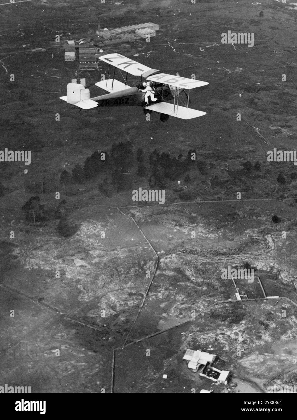 Kurz davor, einen aufregenden Fallschirmsprung zu machen:-- dieses einzigartige Foto. Aus einem anderen Flugzeug genommen. Zeigt Pilot Officer 'Scotty' Fraser kurz bevor er aus einem Flugzeug springt, um einen verzögerten Abstieg aus einer Höhe von 2000 Fuß zu machen. Er hat seine vier kompletten Schläger, bevor er den Fallschirm loslässt. Seine gewagten Darbietungen begeisterten große Menschenmassen in allen Teilen Neuseelands. Dieses Bild wurde kürzlich bei einer Luftausstellung in Auckland gesichert. Mai 1932. Stockfoto