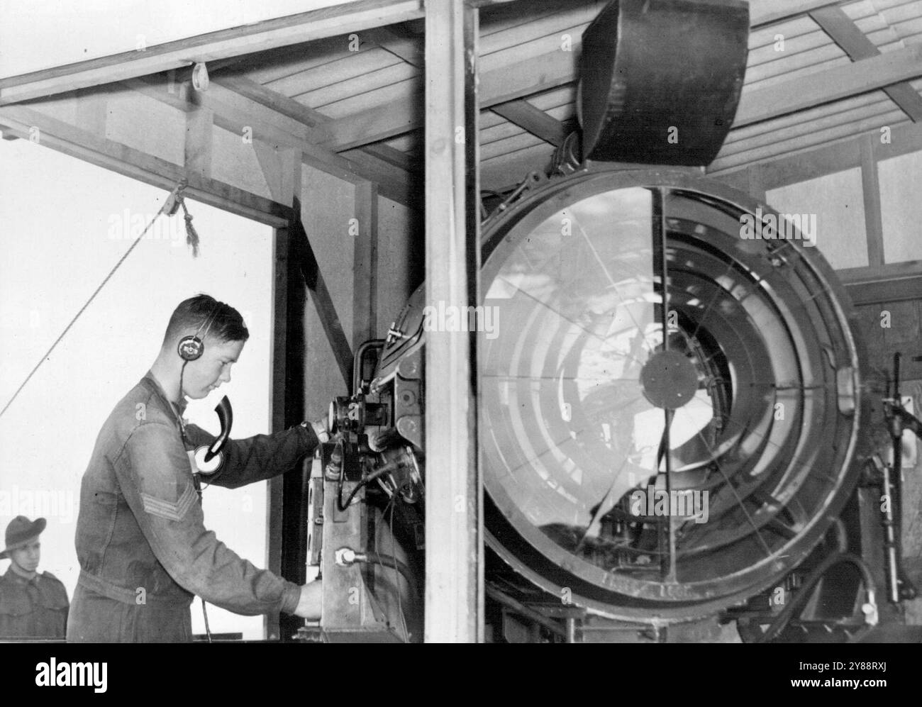 Das sind die großen Lichter, die meilenweit ins Meer strahlen, bereit, jeden Eindringling für die großen Geschütze auszusuchen. Überprüfung des Mechanismus eines Küstensuchscheinwerfers. September 1940. Stockfoto