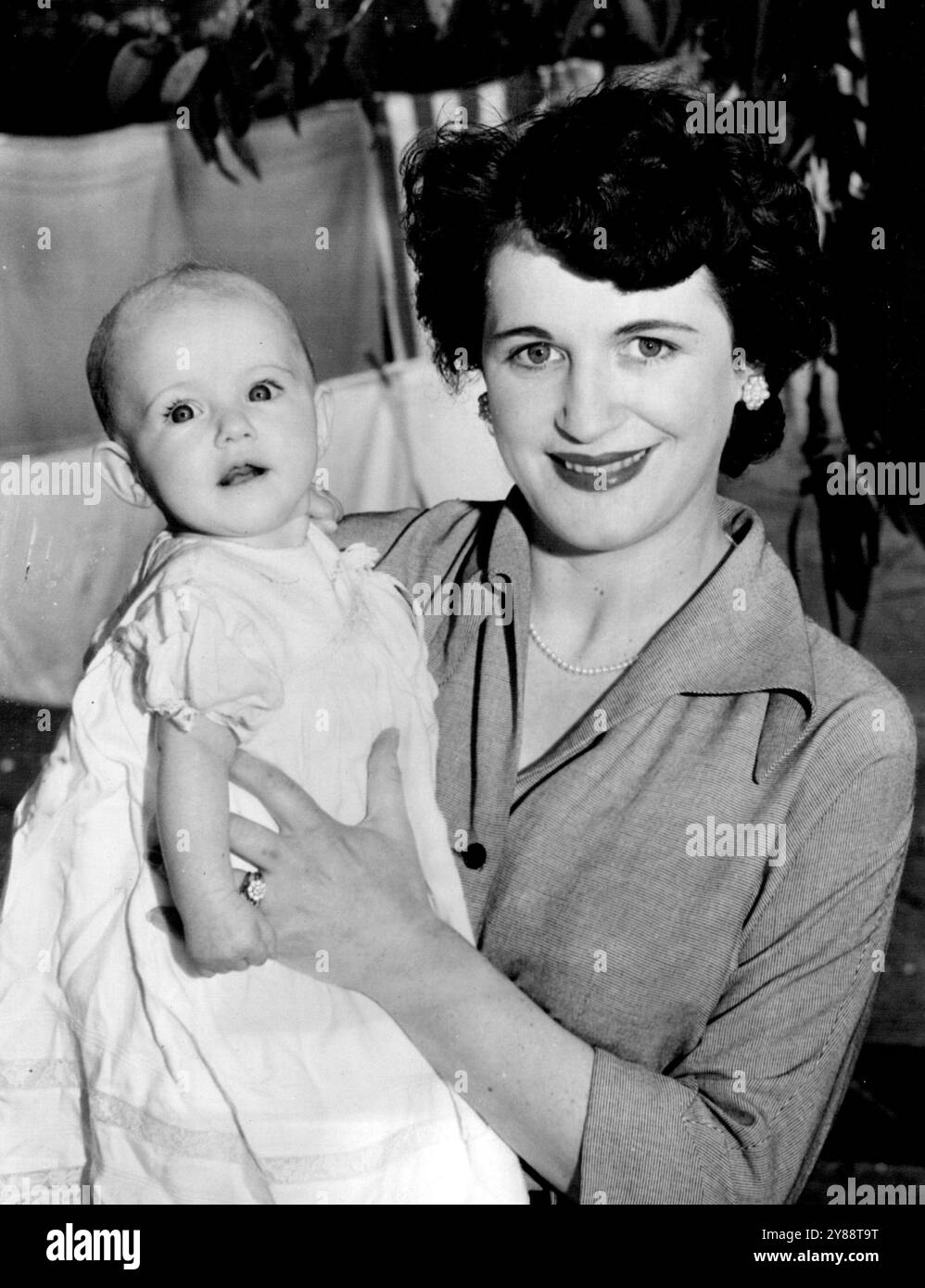 Mrs. J. G. Arthur mit ihrer vier Monate alten Tochter Sharon Gay, dem Apfel ihres Vaterauges, die aus einer Tasse trinkt, weigert sich unverblümt, eine Babyflasche zu benutzen. September 1953. Stockfoto