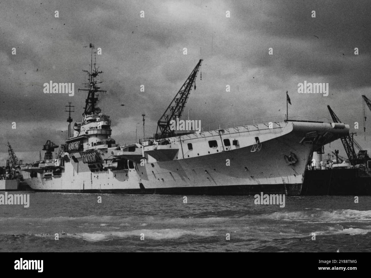 British Aircraft Carrier für die Royal Netherlands Navy: Der Flugzeugträger Karel Doorman (früher H.M.S. „Venerable“ in Plymouth, für die Übergabe. Die Royal Netherlands Navy verfügt nun über einen eigenen Flugzeugträger, nachdem die H.M.S. „Venerable“ von Viscount Hall, First Lord of the Admiralty, in Plymouth übergeben wurde. Der „Ehrwürdige, of14,500 Tonnen, gehört zur Klasse „Koloss“ und wurde in „Karel-Türsteher“ umbenannt. Sie wurde 1945 fertiggestellt und war Teil der Truppe, die die Kapitulation der japanischen Flotte annahm. Mai 1948. (Foto: Sport & General Press Agency Limited). Stockfoto