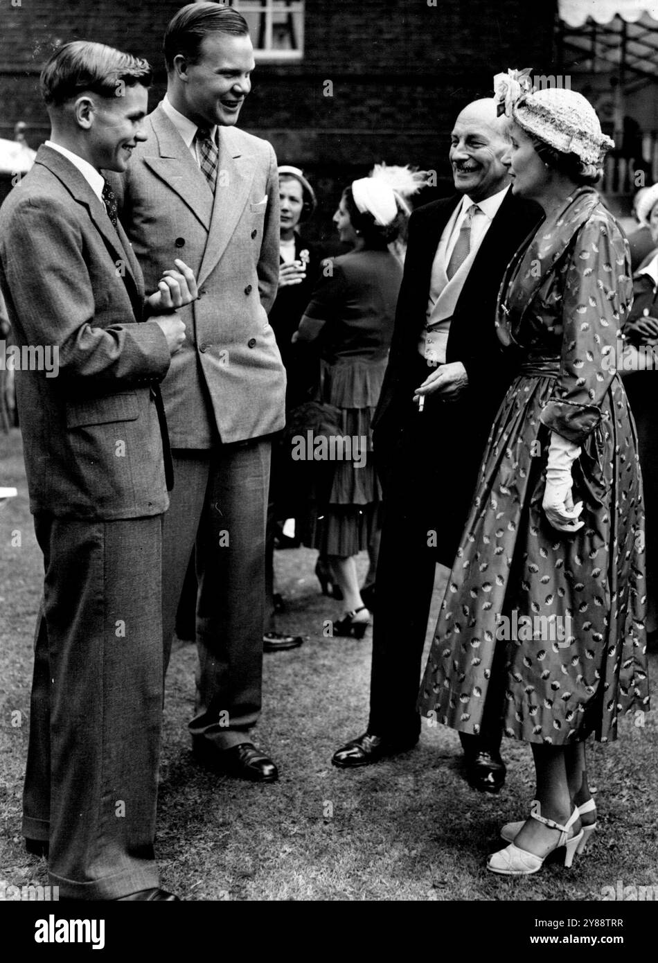 Mr. Attlee hält Eine Gartenparty in Nr. 10 ab. -- Mr. Und Mrs. Attlee fotografierten auf dem Gelände von Nr. 10 und plauderten mit Francis Johnson (18) und William Soutter (17) beide aus Salisbury, Rhodesis, die hier unter dem Anschein des Prinzessin Elizabeth Geburtstags-Fonds sind, bei einem sechswöchigen Besuch. Mr. Und Mrs. Attlee hielten heute eine Gartenparty in der Downing Street 10 statt, zu Hilfe des Victory Club Fund. Juli 1950. Stockfoto