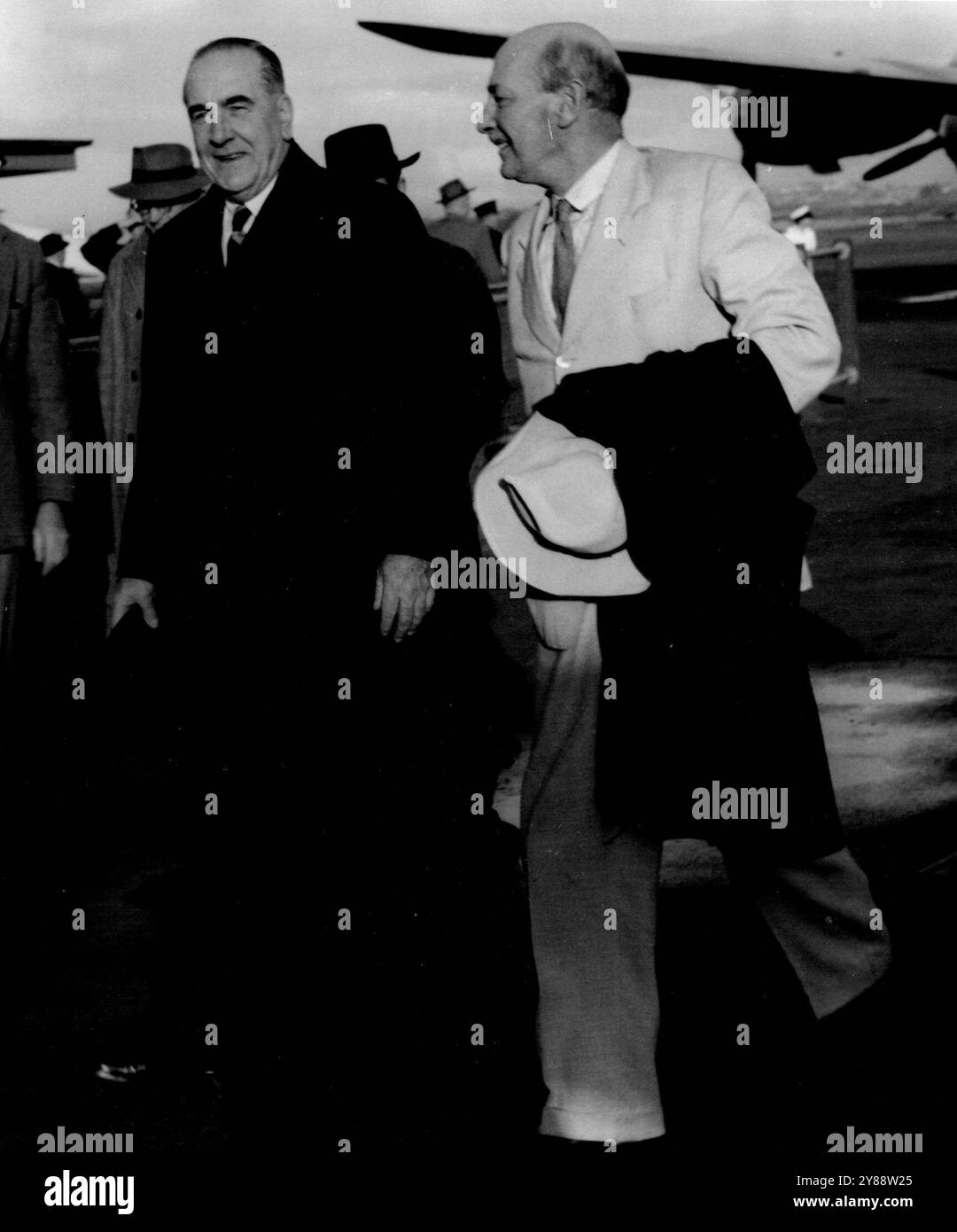 Der britische Labor Leader Attlee wird heute von Sir Eric Harrison, dem Vizepräsidenten des Exekutivrates, aus dem Flugzeug am Flughafen Sydney begleitet. September 1954. (Foto von Associated Newspapers Ltd.) Stockfoto
