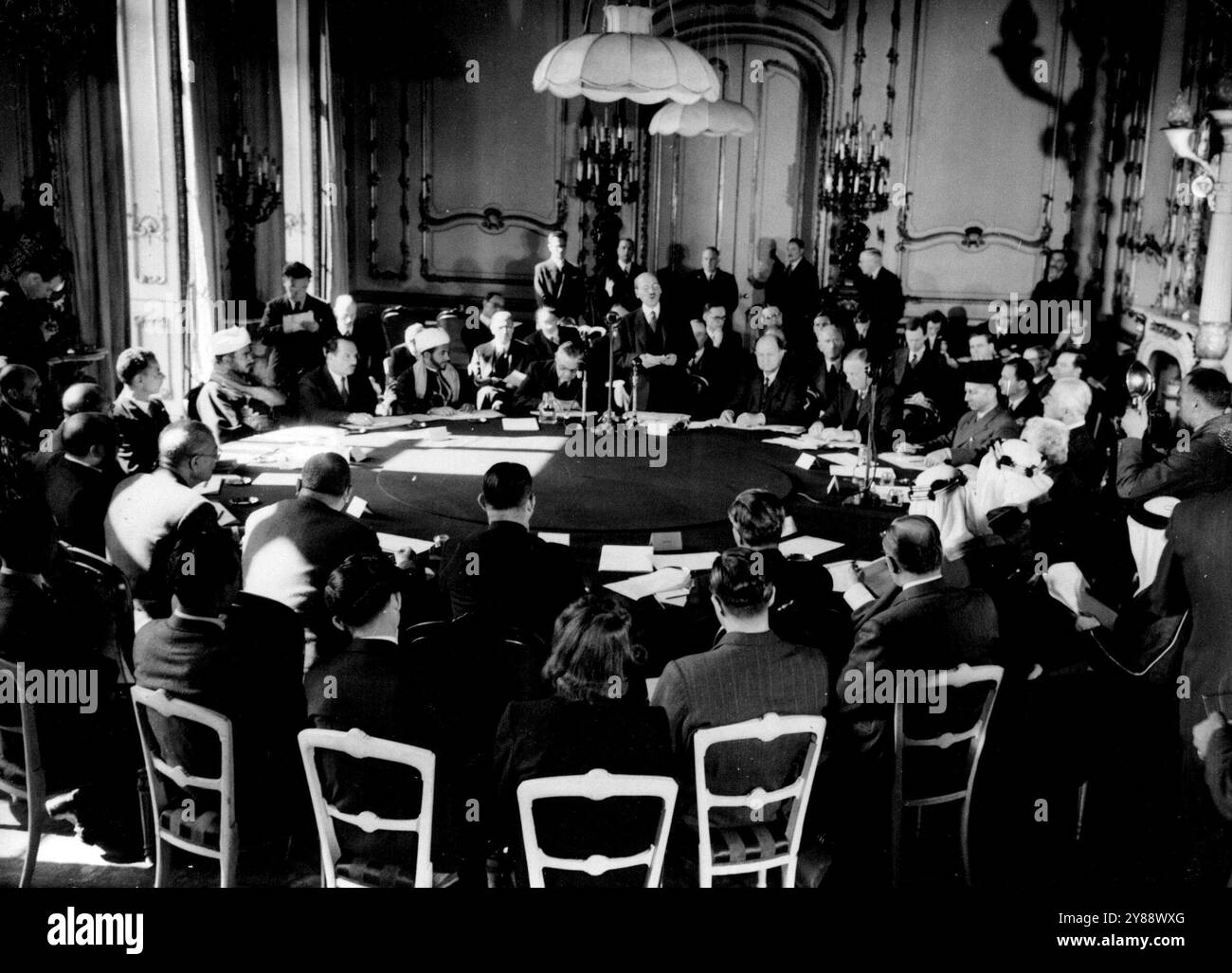 Attlee eröffnet Palästinensische Konferenz -- Mr. Clement Attlee spricht bei der Eröffnung der Konferenz. Am Tisch sind - Premierminister - Herr Ernest Bevin, britischer Außenminister; El Seid Ali Hasan Ibrahim, Dr. Fauzi al-Mulki, Emir Saif-ul-Islam Abdullah (Mitglieder der jemenitischen Delegation); **** Pascha; Mtro Abdul Monoim Mustafa, Mtro Fathi Al Akkad, Ahmed Amin Bey, Sanhouri Pascha (ägyptische Delegation); Dr. Fadhol Jamali (Irak); Camillo Bey Chamoun (Libanon); Emir Feisal, Scheich Hafiz Wahba (Saudi-arabische Delegation); Samir Pascha Rifai (Transjordanischer Delegierter); Sir Norman Brook (Briten Stockfoto