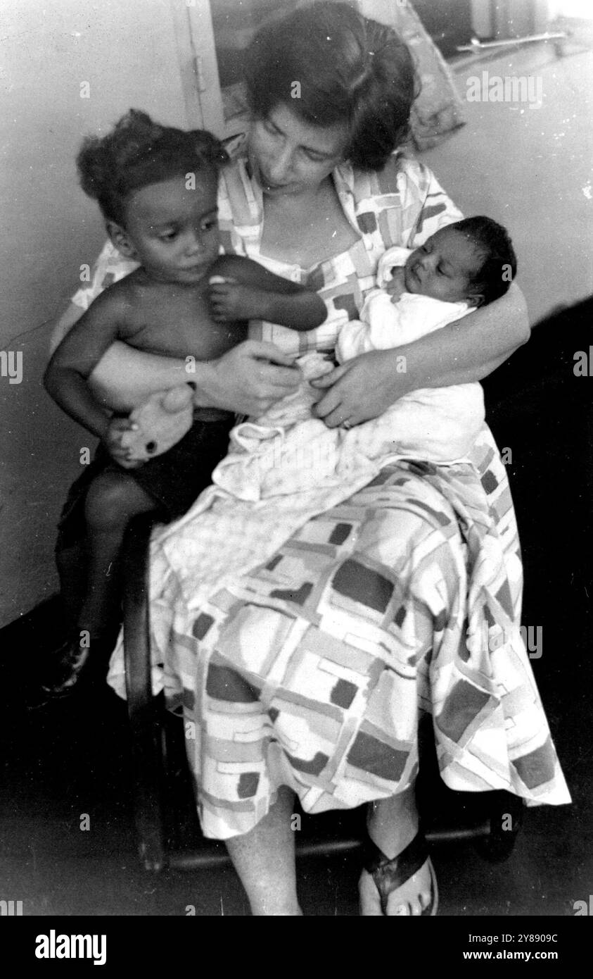 Peggy Cripps' Tochter One Month Old -- Baby Isobel, ein Monat alt, macht ihren ersten Auftritt vor der Kamera mit Bruder Kwame und ihrer Mutter, Mrs. Peggy Appiah, der jüngsten Tochter des verstorbenen Sir Stafford Cripps, ehemaliger britischer Finanzkanzler und prominentes Mitglied der Labour Party. Isobel – voller Name Isobel Takyiwah Appiah – wurde in einem Schweizer Missionskrankenhaus in der Nähe ihrer Eltern in Kumasi, Gold Coast geboren. Bruder Kwame ist ein Jahr alt. Frau . Appiah ging nach ihrer Heirat mit Mr. Joe Appiah, dem Sohn eines Ashanti-Häuptlings, an die Gold Coast. Dezember 1955. Stockfoto