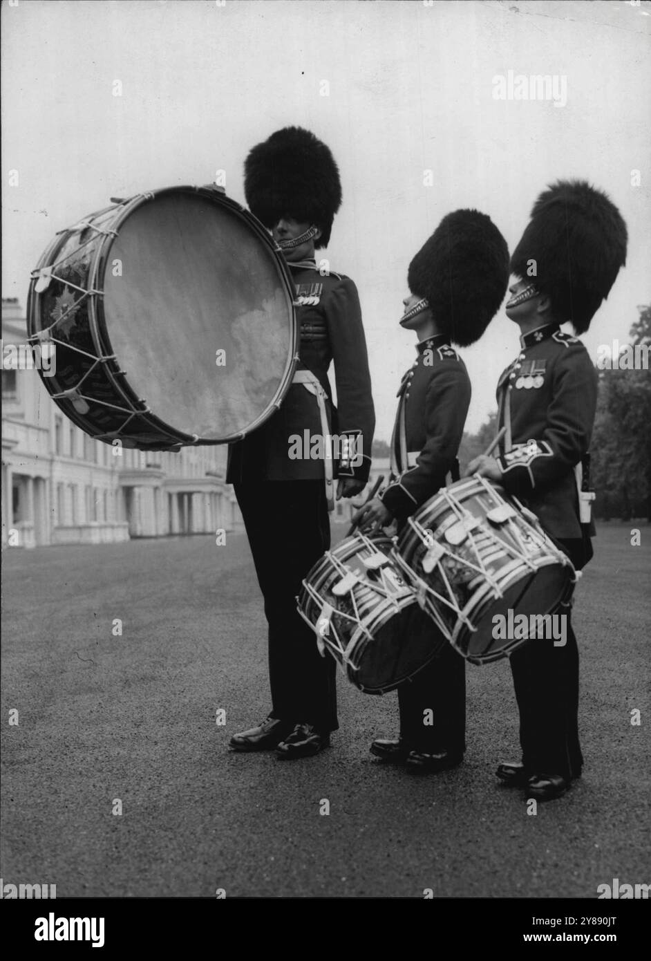 Selbst die Guards schauen auf den HimmelsDie Bandsmen der Irish Guards sind große Männer, aber selbst sie müssen zum höchsten Mitglied der Brigade der Guards aufschauen - Band Colour Sergeant F. Clarke, 1,5m 7½ Zoll ohne Bärenfell. Sergeant Clarke aus Fulham, London, wird mit den Musikern Geoffrey Wareham aus Pinner (Mitte) und Joe Taylor, Ashton-under-Lyme (rechts) in Wellington Barricks, London, dargestellt, wo sich heute (Mittwoch) die Kurve der Irish Guards auf ihren bevorstehenden Besuch in Amerika und Kanada vorbereitete. August 1954. Stockfoto