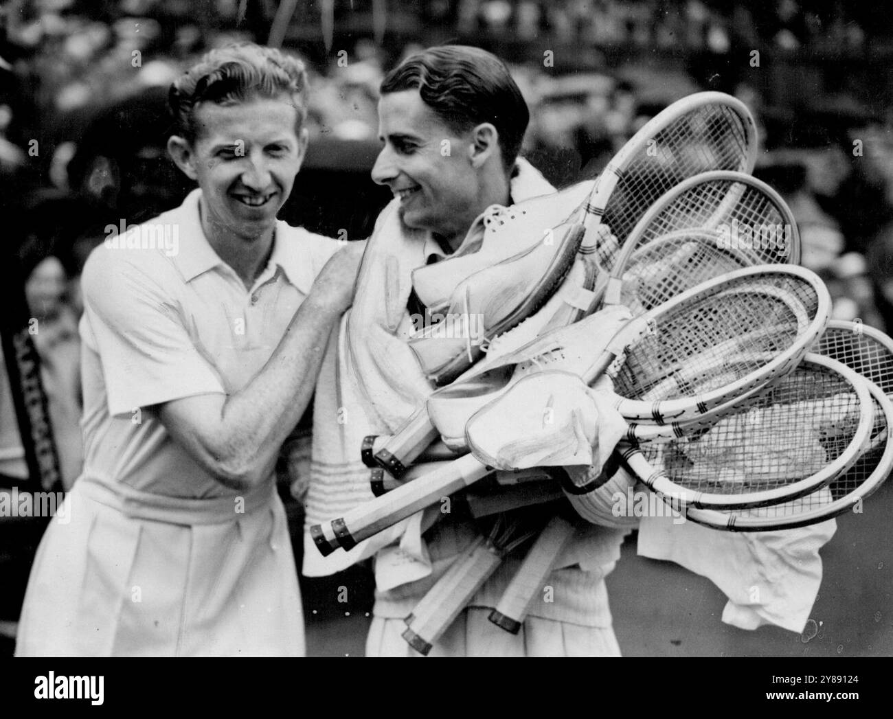 Budge behält seine Wimbledon-Meisterschaft - Beats Austin in drei Straight Sets - Donald Budge (links) posiert lachend mit H. W. Austin, der mit Schlägern und Schuhen bewaffnet ist, nach ihrem heutigen Spiel. Donald Budge, der amerikanische Champion, behielt heute Nachmittag seinen Tennistitel in Wimbledon, als er H.W. Austin, Großbritanniens Nummer 1 Spieler in drei Reihen besiegte. Juli 1938. (Foto von Keystone). Stockfoto