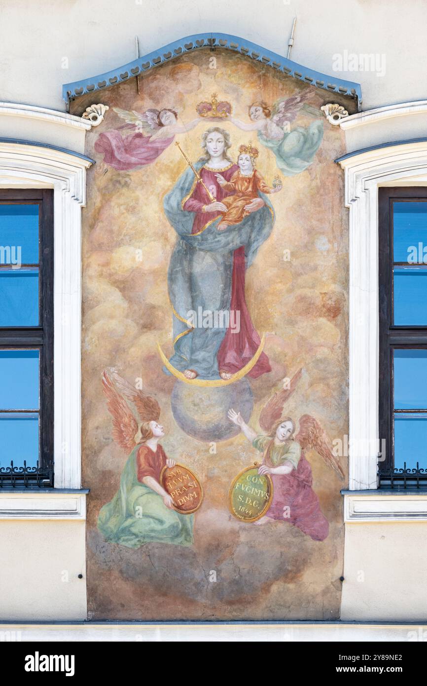 Gemälde der Jungfrau Maria mit dem Jesuskind an der Wand von „Kamienica Pod Obrazem“ auf Rynek Główny [Hauptplatz] in Kraków, Polen. Stockfoto