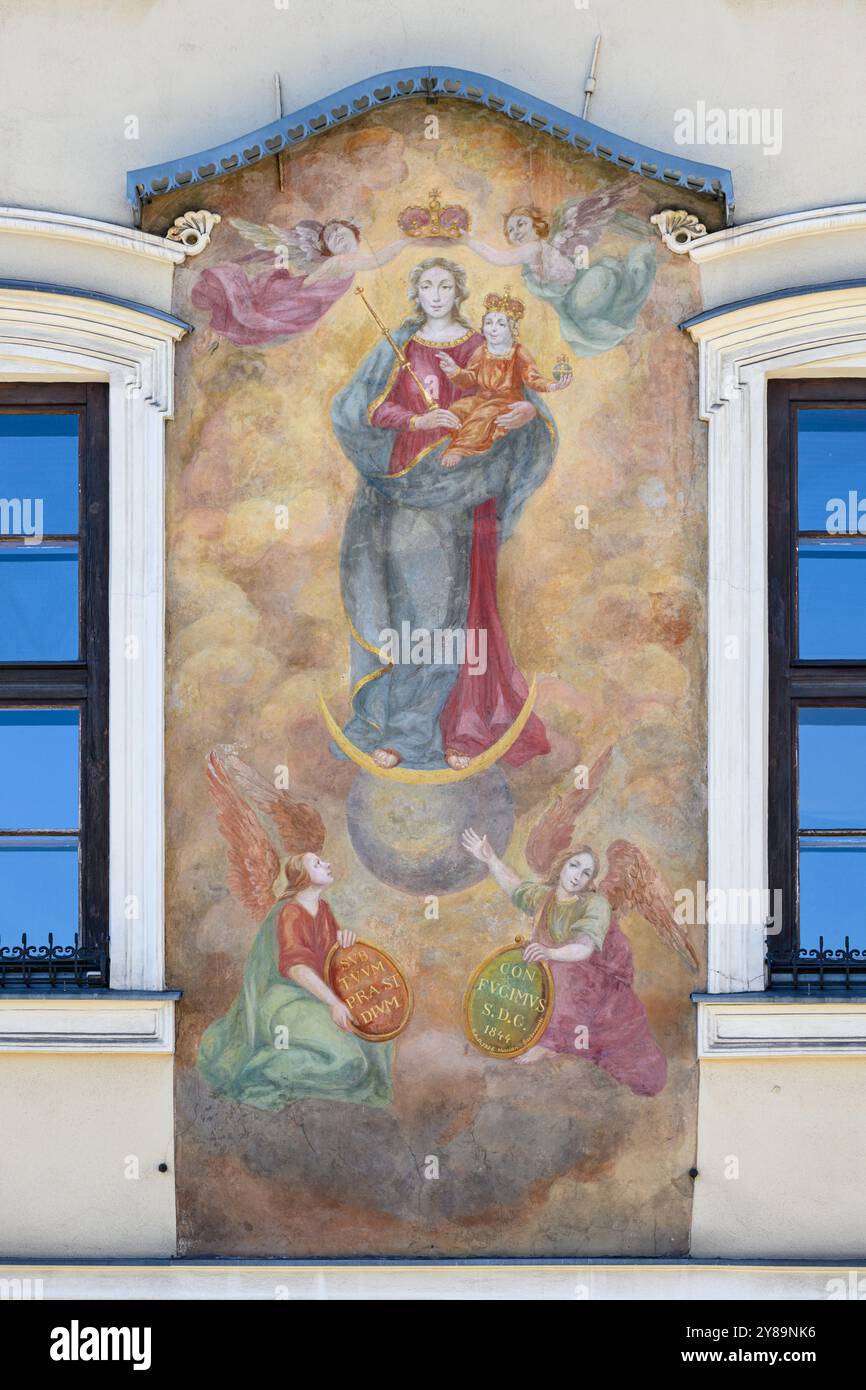 Gemälde der Jungfrau Maria mit dem Jesuskind an der Wand von „Kamienica Pod Obrazem“ auf Rynek Główny [Hauptplatz] in Kraków, Polen. Stockfoto