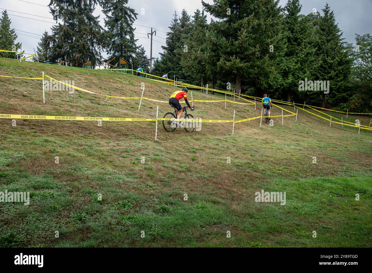 WA25665-00...WASHINGTON - Cyclocross-Rennfahrer bereiten sich auf einen steilen Aufstieg auf die Bergspitze vor. Stockfoto