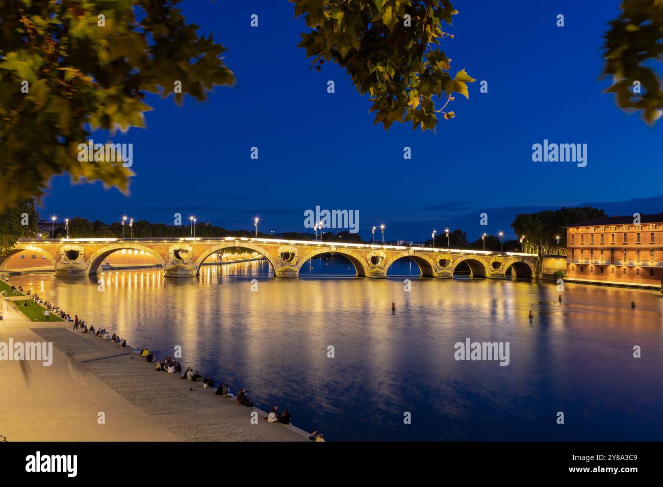 Goldener Sonnenuntergang über dem Fluss Garonne und Pont Neuf in der Innenstadt von Toulouse. Diese Bogenbrücke gilt als ein Meisterwerk der Renaissance. Die Brücke i Stockfoto