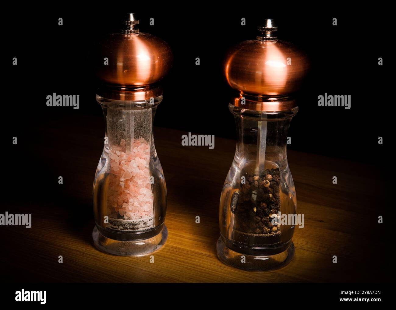 Set aus Kupfer Salz- und Pfeffermühle isoliert auf einem Holztisch Stockfoto
