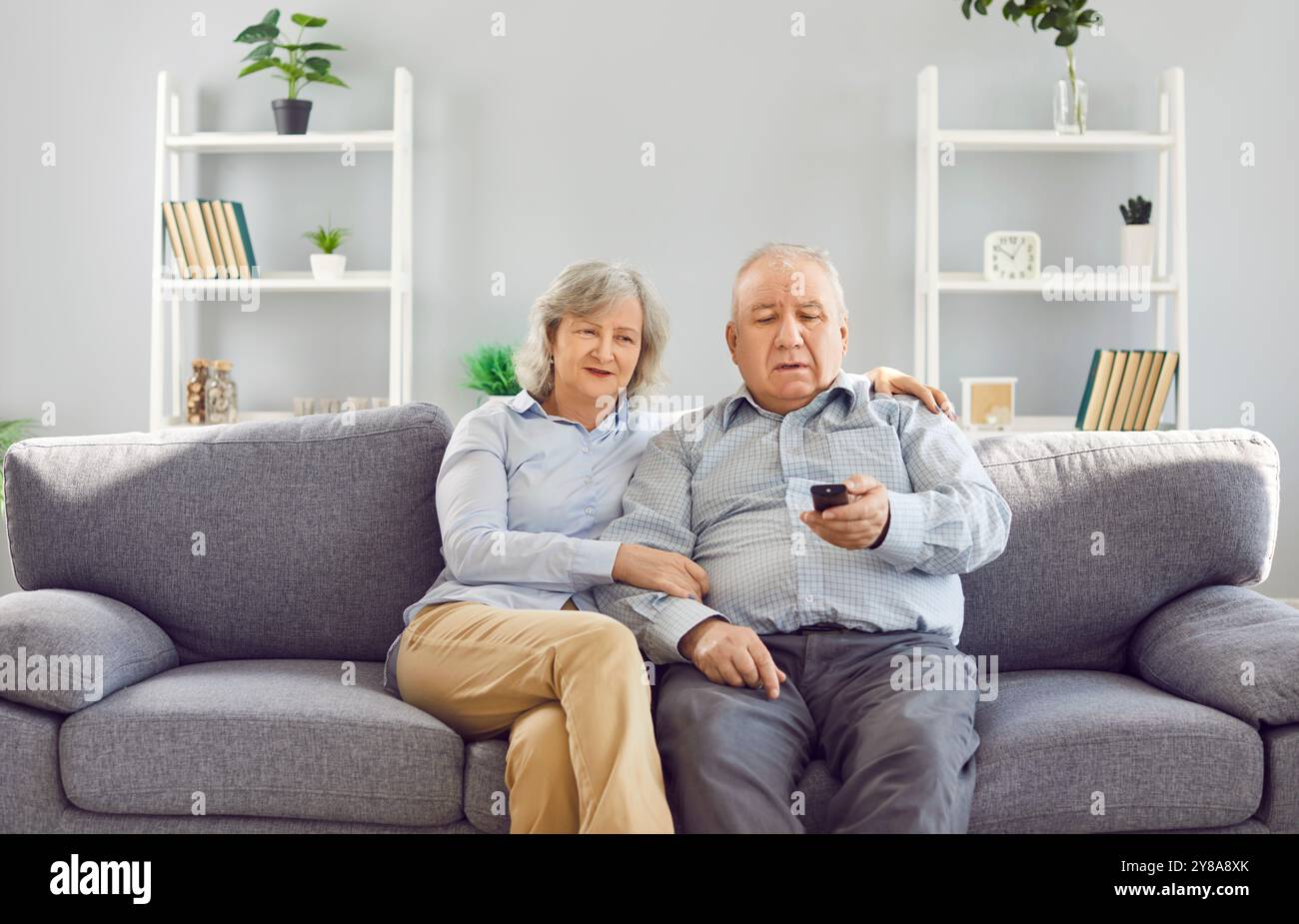 Pensioniertes älteres Ehepaar, graues Haar älteres liebevolles altes Familienpaar, das sich auf der Couch zu Hause entspannt Stockfoto