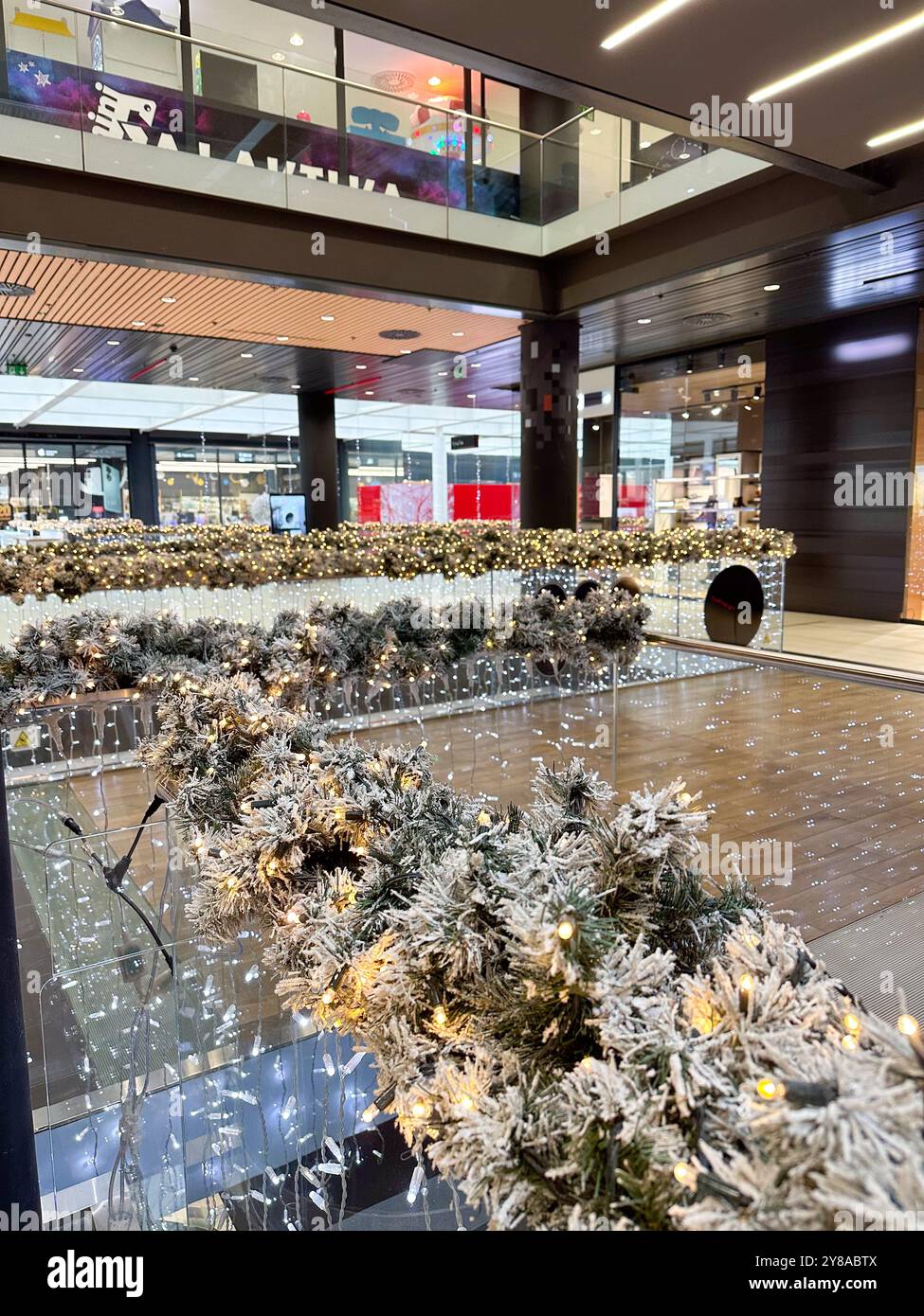 Die Nahaufnahme zeigt eine wunderschön mattierte Girlande mit funkelnden Lichtern im weihnachtlichen festlichen Innenbereich. Warmes Glühen erzeugt einen magischen Eindruck Stockfoto