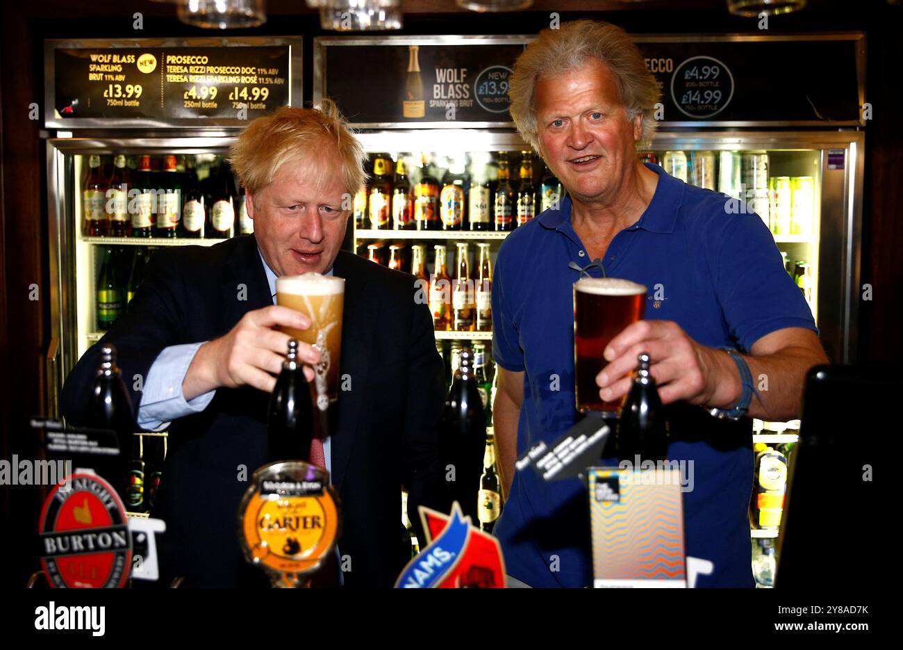 Aktenfoto vom 07/19 (damals)Kandidat der Konservativen Partei Boris Johnson bei einem Besuch in der Wetherspoons Metropolitan Bar in London mit Tim Martin, dem Vorsitzenden von JD Wetherspoon. Herr Martin hat "etwas dumme" Vorschläge von Akademikern kritisiert, Bier in zwei-Drittel-Pint-Maßnahmen zu servieren, da er die Einführung weiterer Regelungen für den unter Druck stehenden Pub-Sektor gefordert hat. Ausgabedatum: Freitag, 4. Oktober 2024. Stockfoto