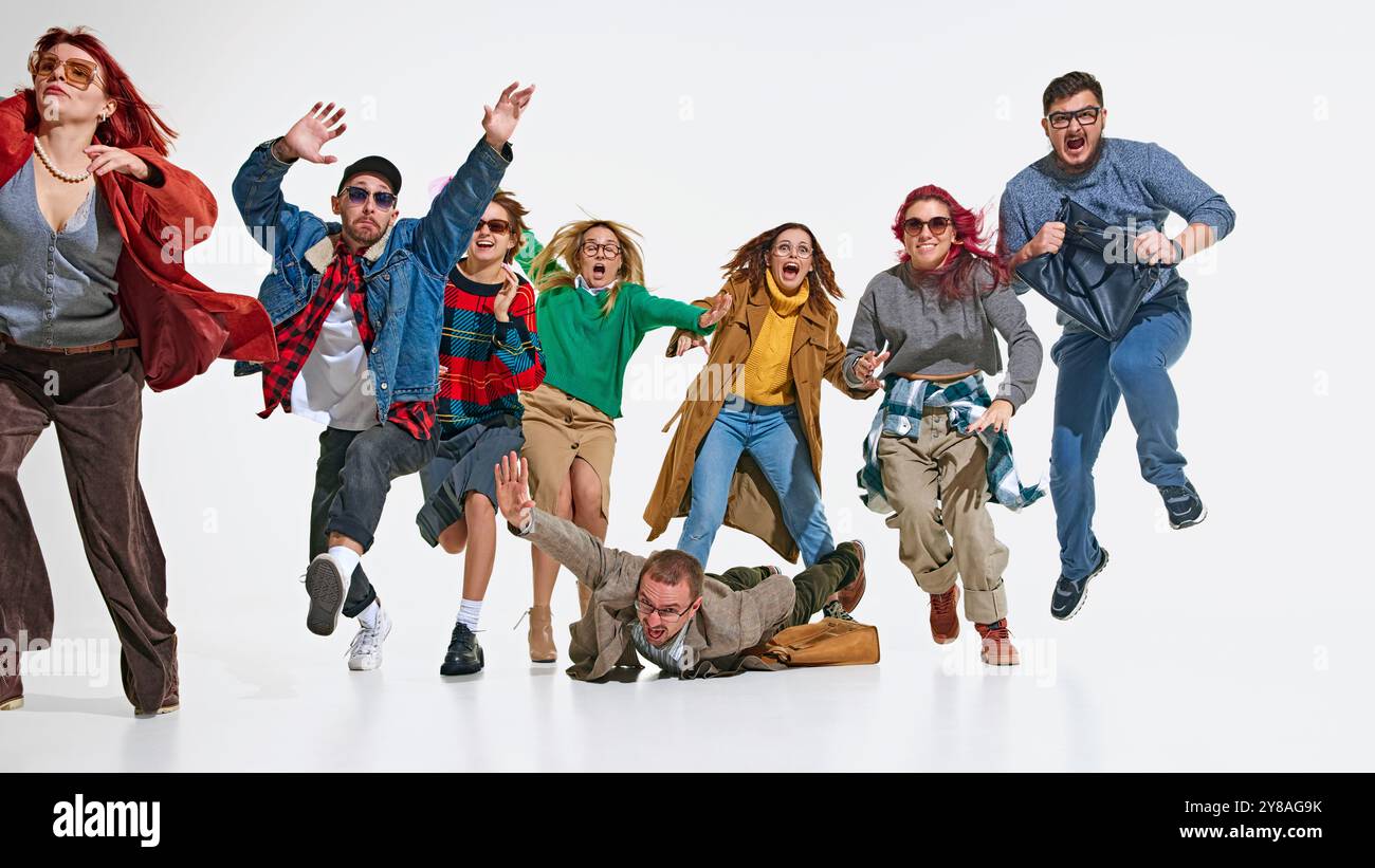 Shopping-Wahnsinn. Emotionale Menschen in stilvollen Herbstoutfits, die mit Leidenschaft und Dringlichkeit vorwärtseilen, um die besten Einkaufsangebote zu erhalten. Stockfoto