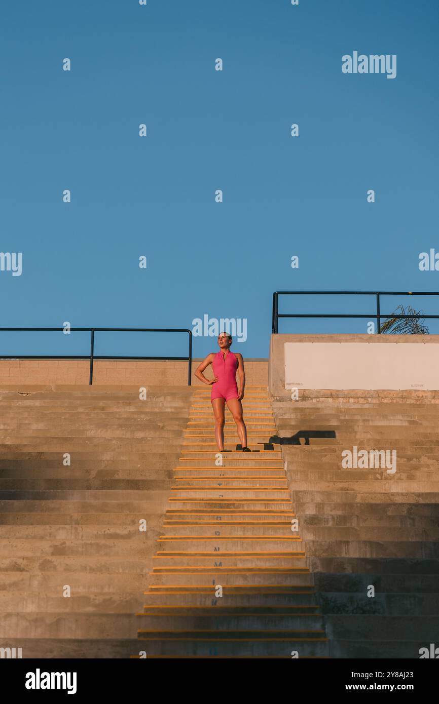 Passen Sie weibliche Athletin, die während des Workouts auf der Treppe steht Stockfoto