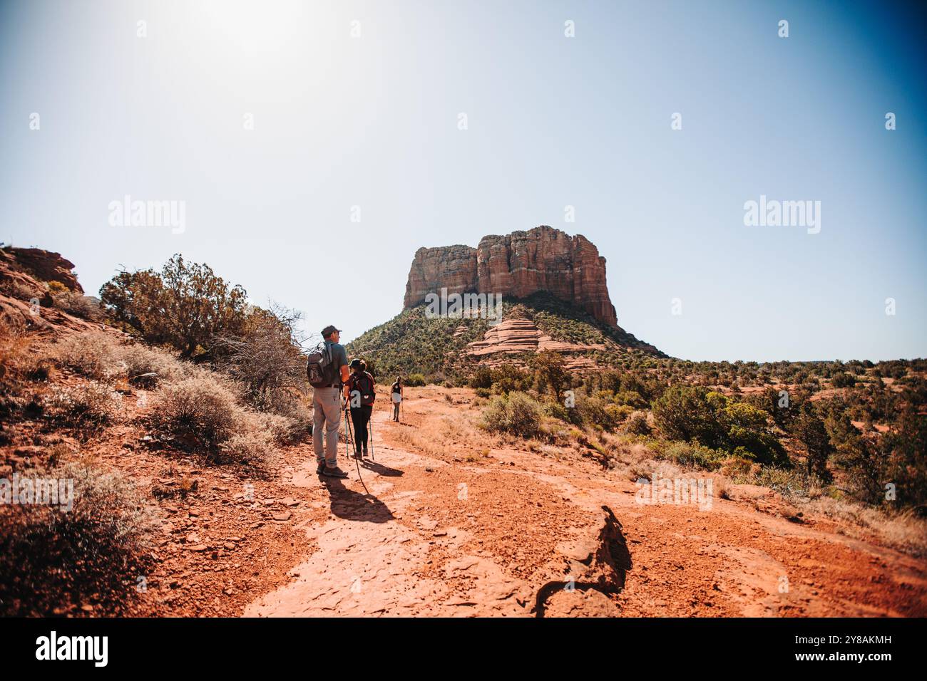 Wanderer, die auf einem roten Wüstenpfad mit markantem butte in laufen Stockfoto