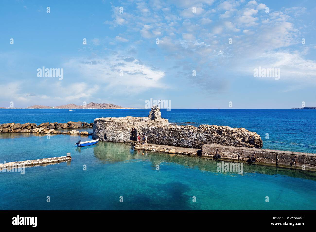 Ruhige Aussicht auf die mittelalterliche venezianische Festung in Naousa, Paros, Griechenland, mit ruhigem türkisfarbenem Wasser und einer malerischen Küstenlandschaft Stockfoto