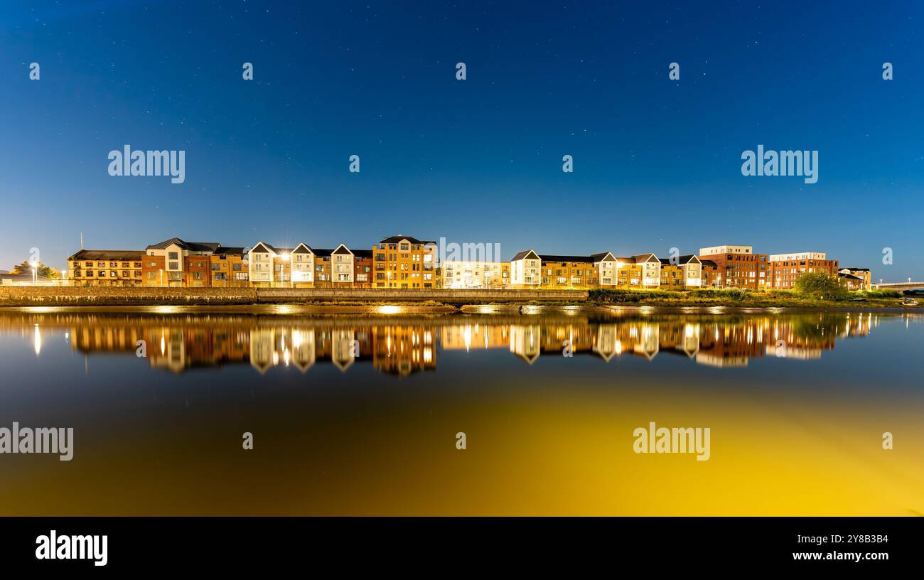 Barnstaple bei Nacht, moderne Häuser spiegeln sich im Fluss Taw. Lange Belichtung Stockfoto