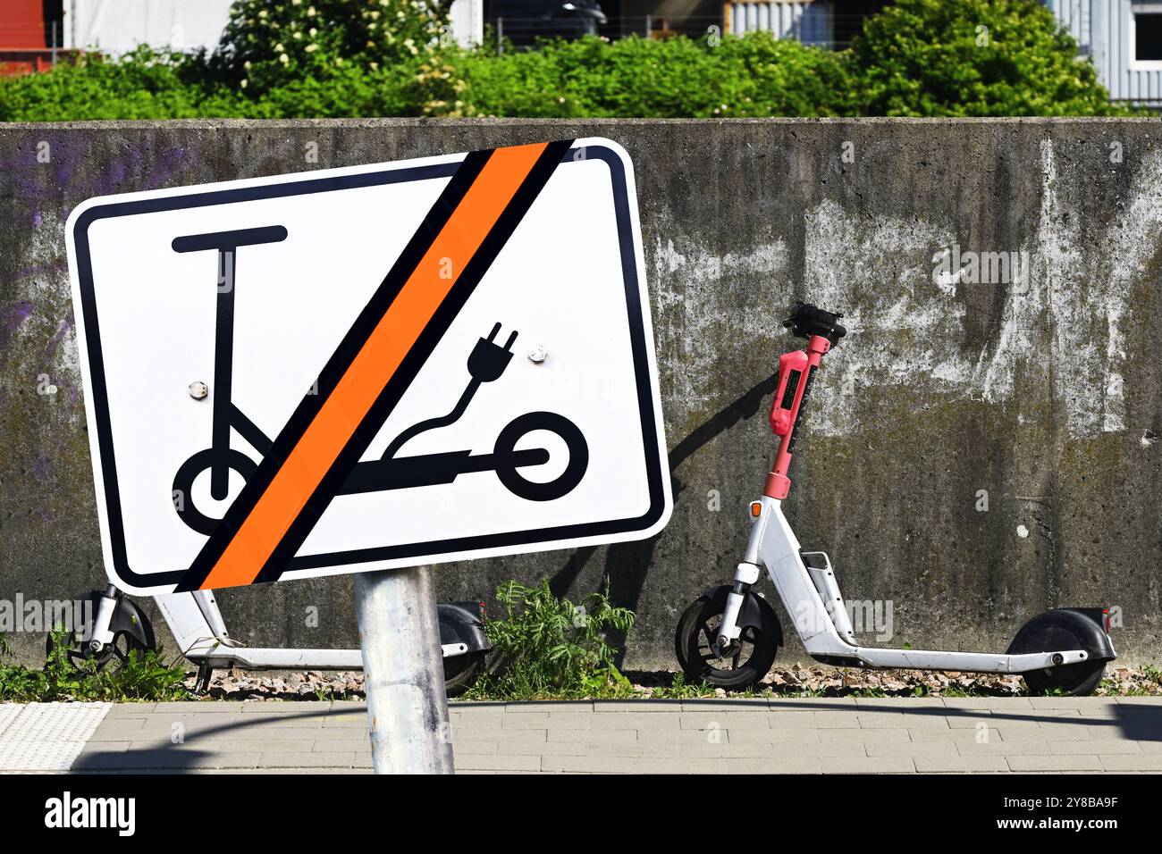 FOTOMONTAGE, E-Scooter auf dem Bürgersteig geparkt und Verbotsschild mit E-Scooter-Symbol, FOTOMONTAGE, auf dem Fußweg abgesteller E-Scooter und Verb Stockfoto