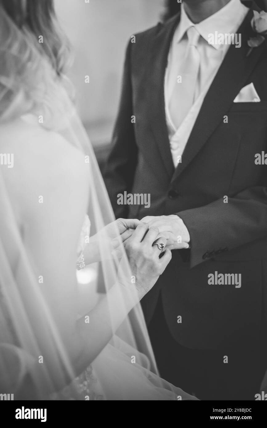 Braut legt den Ring auf die Hand des Bräutigams Stockfoto