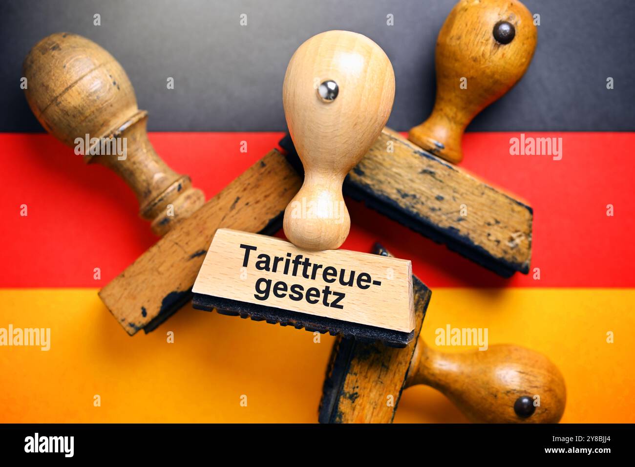 FOTOMONTAGE, Stempel mit Aufschrift Tariftreuegesetz auf der Flagge Deutschlands, FOTOMONTAGE, Stempel mit Aufschrift Tariftreuegesetz auf der Fahne von D Stockfoto