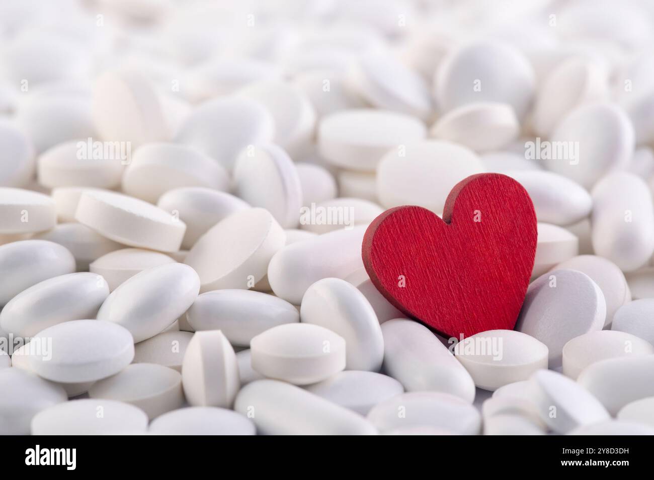 Rotes Herz auf dem Haufen vieler verschiedener Arzneimittelpillen Stockfoto