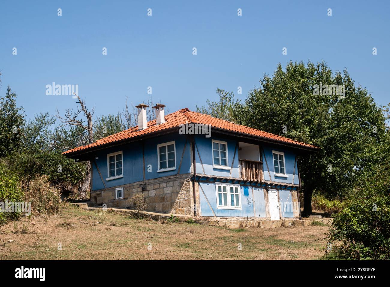 Altes blau lackiertes Landhaus am Hügel des Balkandorfes Nahaufnahme an sonnigen Sommertagen Stockfoto