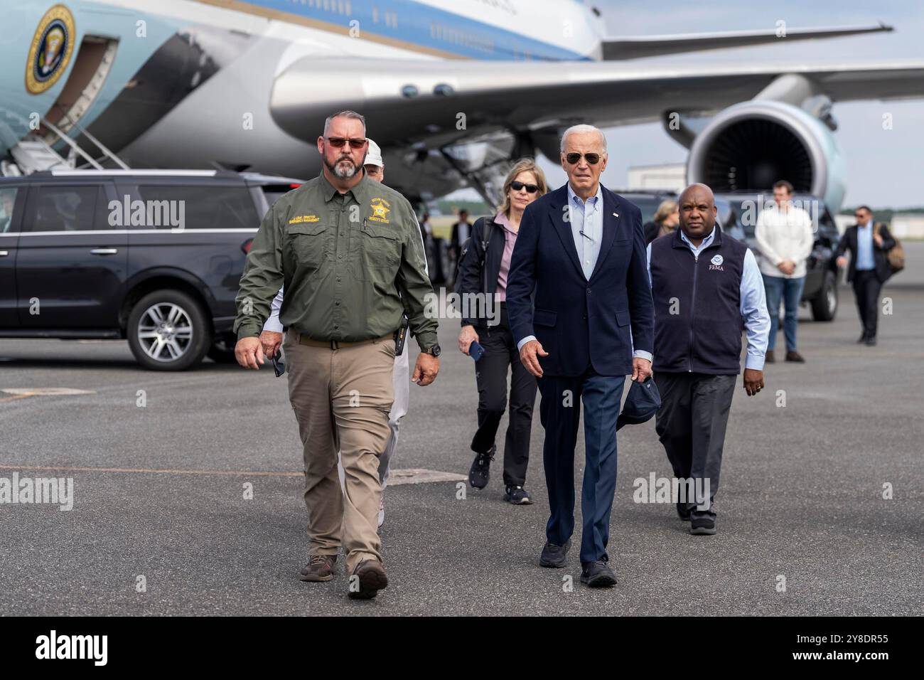 Tallahassee, Usa. Oktober 2024. U. US-Präsident Joe Biden, rechts, geht mit Taylor County Emegency Management Director John Louk, links, bevor er an Bord der Marine One zu einer Luftfahrt durch die Gebiete, die Hurrikan Helene am 3. Oktober 2024 in Tallahassee, Florida, führte. Quelle: Cameron Smith/White House Photo/Alamy Live News Stockfoto