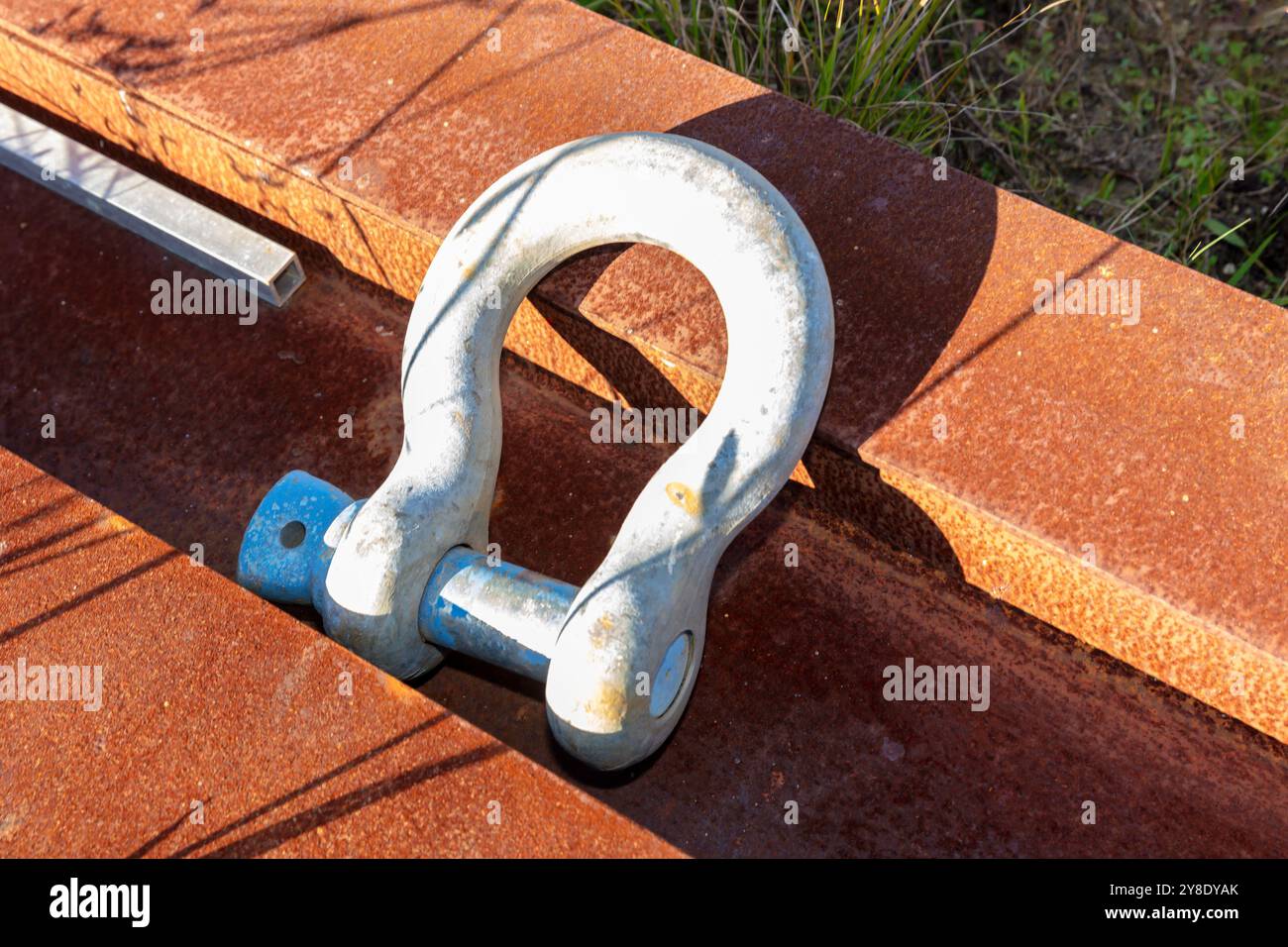 Foto eines großen und rostigen industriellen D-Bolts, der entsorgt und bei Wettereinflüssen draußen gelassen wurde, um sich zu verschlechtern. Stockfoto