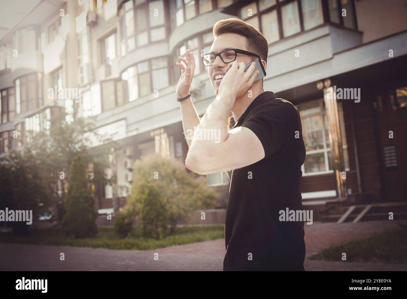 Fröhlicher junger Mann seine Hand winken, um Hallo zu sagen Stockfoto