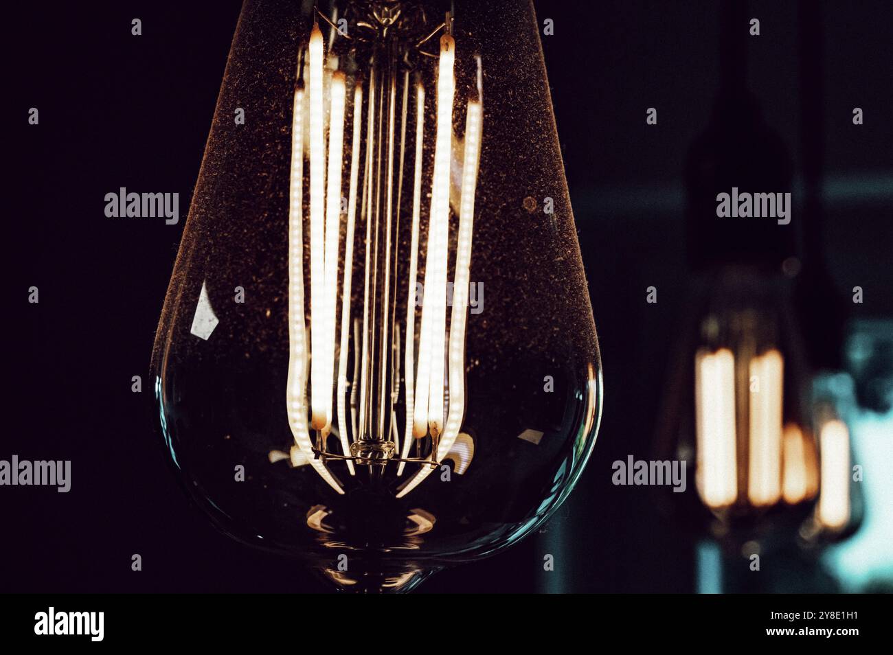 Die Glühbirne im Edison-Stil in dunkler Umgebung sorgt für eine warme Atmosphäre Stockfoto