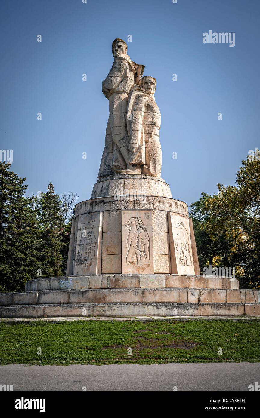 Eine detaillierte Steinskulptur (Pantheon Varna) mit Reliefs, die vor einem klaren blauen Himmel stehen, Varna, Bulgarien, Europa Stockfoto