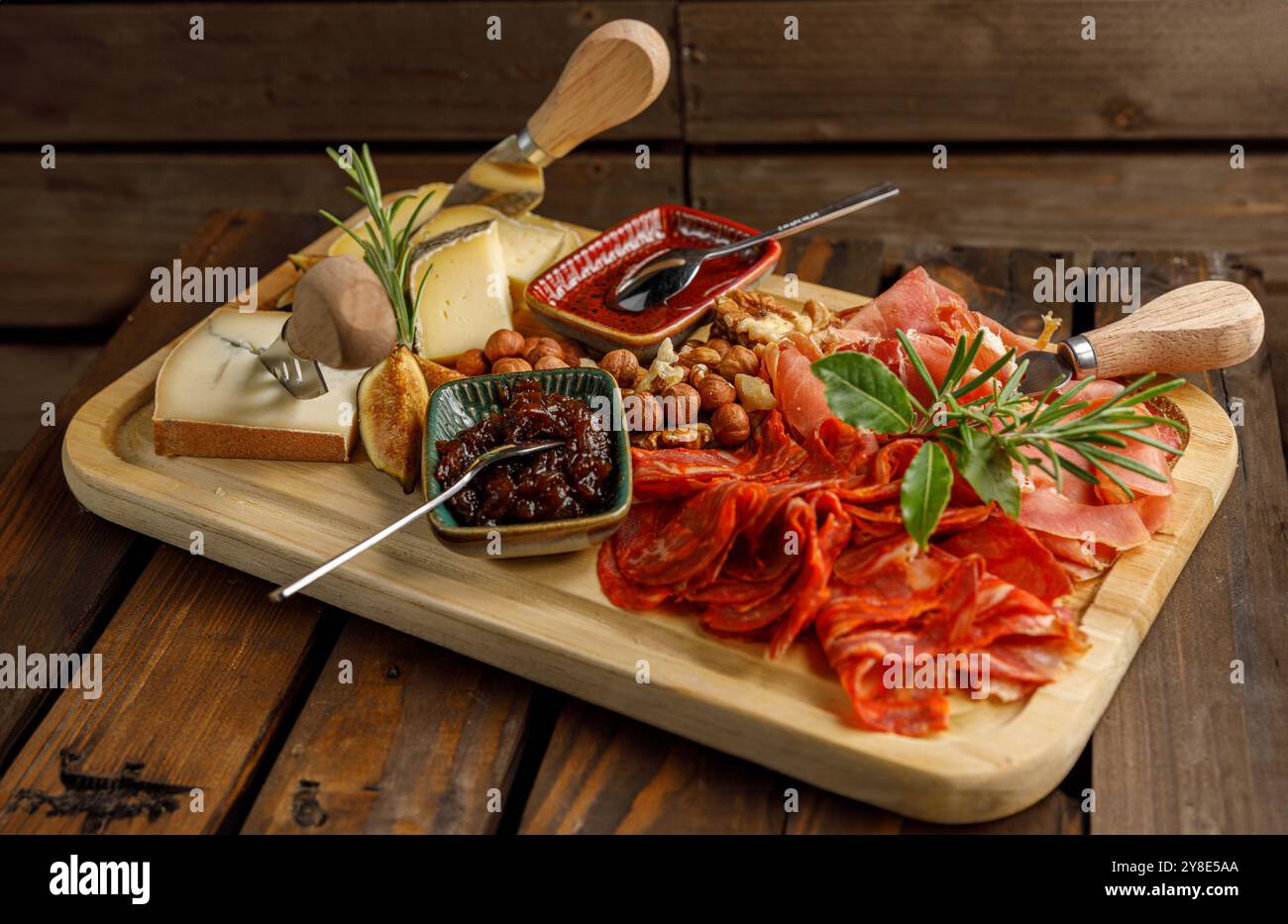 Ein wunderschön gestaltetes Gourmet-Charcuterie-Board mit einer Auswahl an Käse und Nüssen Stockfoto