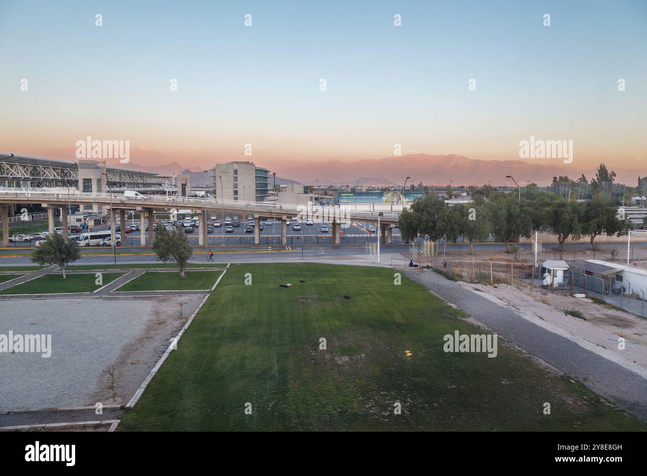 Eine Brücke zum Flughafen und den Anden (Cordillera de los Andes) bei Sonnenuntergang hinten, Santiago de Chile Stockfoto