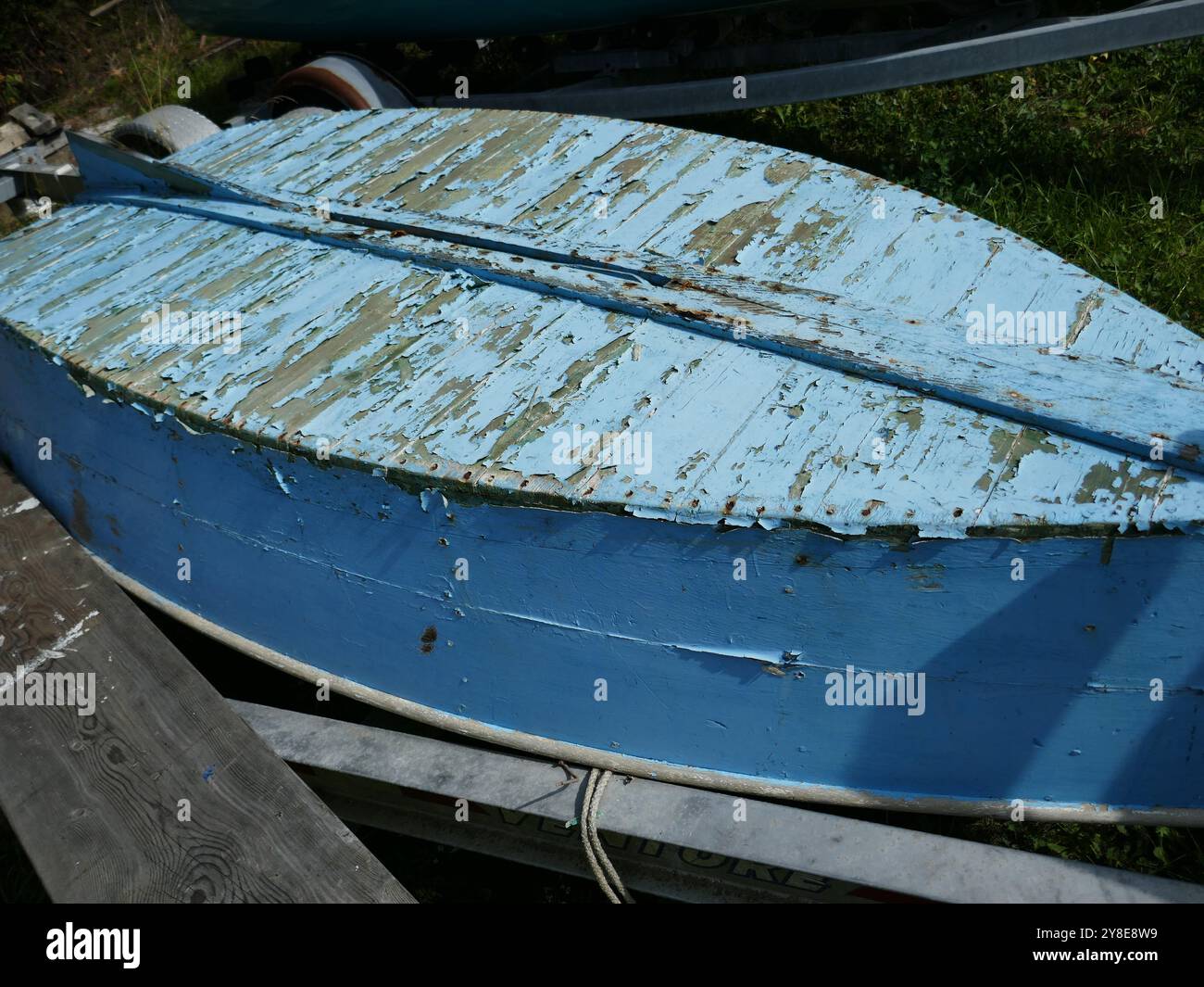 Altes hölzernes Boot mit abplattender blauer Farbe auf den Kopf gestellt Stockfoto