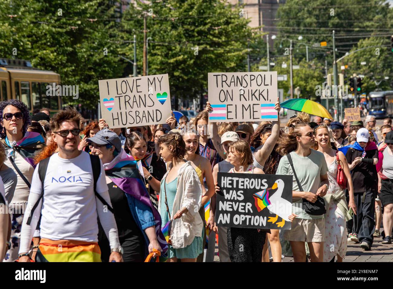 Menschen mit handgefertigten Schildern bei der Helsinki Pride 2024 Parade auf der Mannerheimintie in Helsinki, Finnland Stockfoto