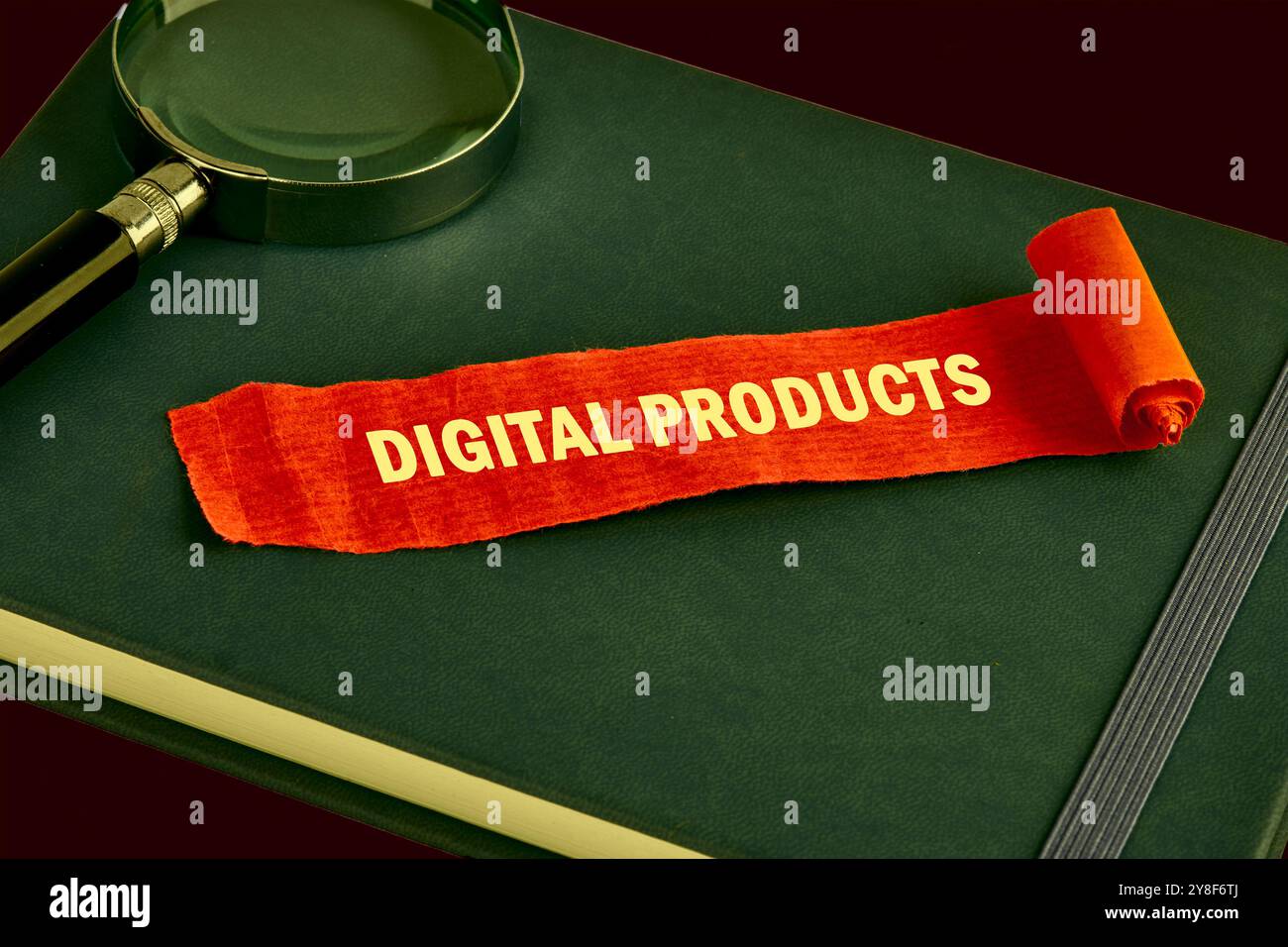 Das Konzept des Info-Geschäfts. Der Text DIGITALER PRODUKTE ist auf einem Stück aufgeklappten roten Notiz, Papier auf einem grünen Buch geschrieben. Gesättigte Farben Stockfoto