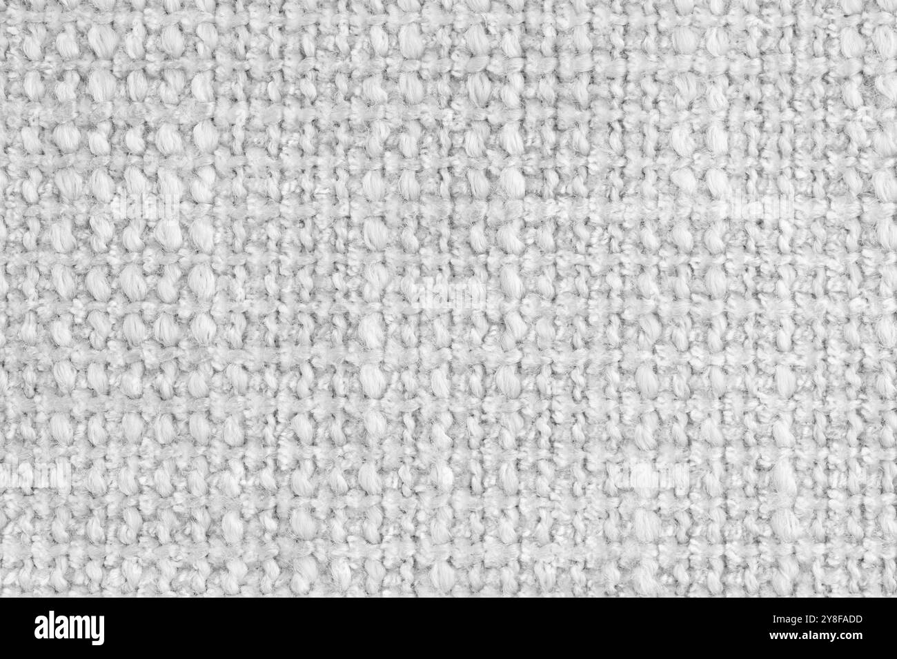 Textur des weißen Jacquard-Gewebes aus rauem Gewebe, Stoffstrukturhintergrund, Nahaufnahme, Makro. Material für Heimtextilien, Polster und Vorhangdekor, Stockfoto