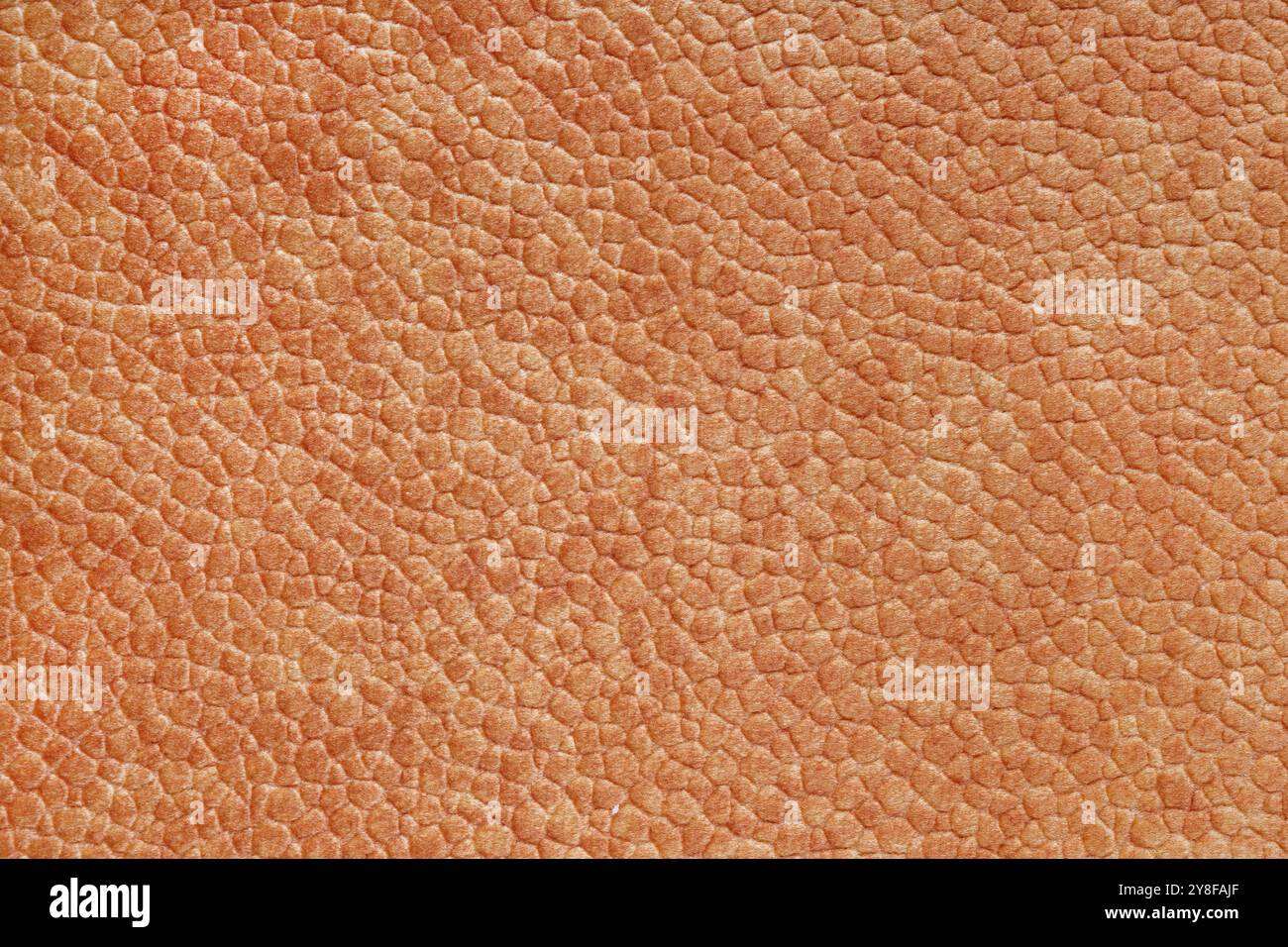 Velours-Stoff in Orange mit geprägtem Muster wie Lederstruktur in Nahaufnahme, Makro. Polsterung dekorative Stoffstruktur, Leinwand für Hom Stockfoto