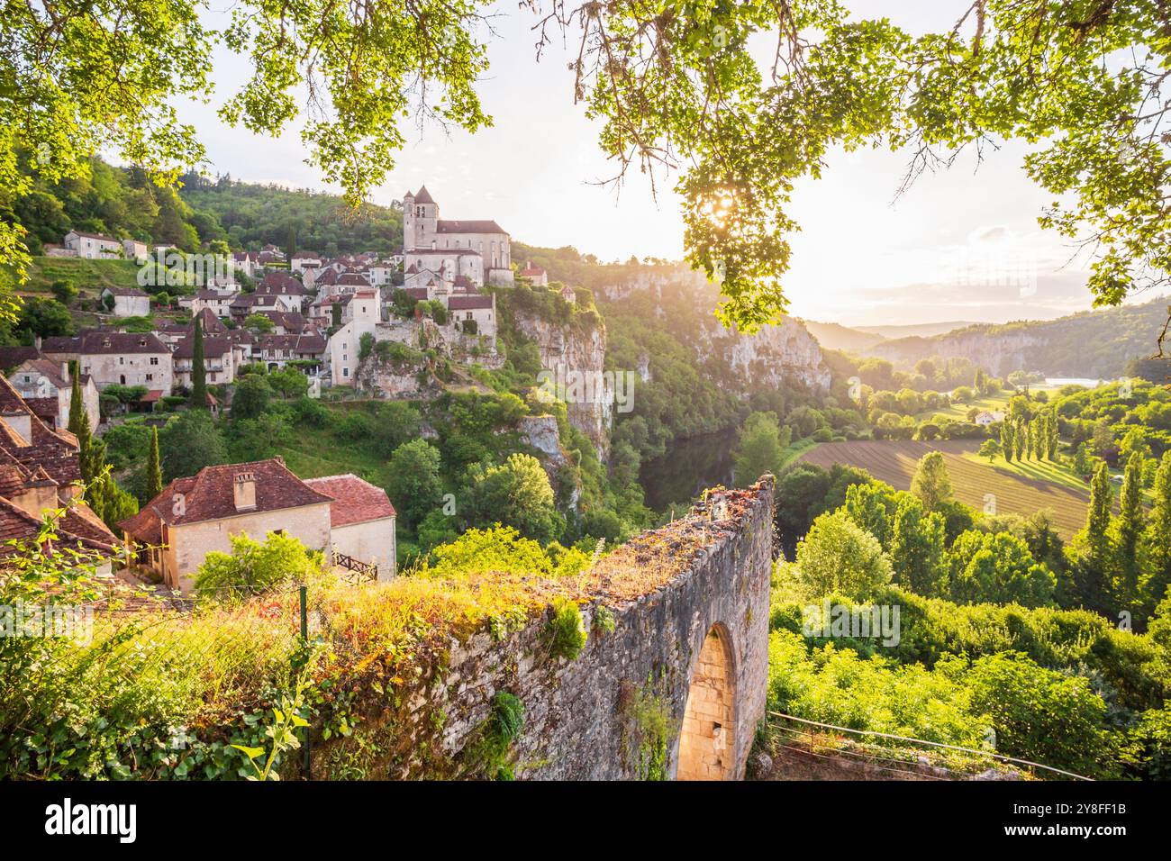 Altes Dorf an den Klippen Saint-Cirq-Lapopie, eines der schönsten Dörfer Frankreichs, angenehm eingerahmt von der Natur beim Sonnenuntergang im Lot Depar Stockfoto