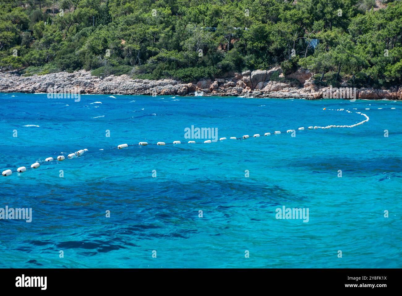 Eine schwimmende Pontonboje auf ruhigem blauem Meer bietet eine ruhige und friedliche Meereslandschaft mit lebhaften Farben und klaren Reflexen. Stockfoto